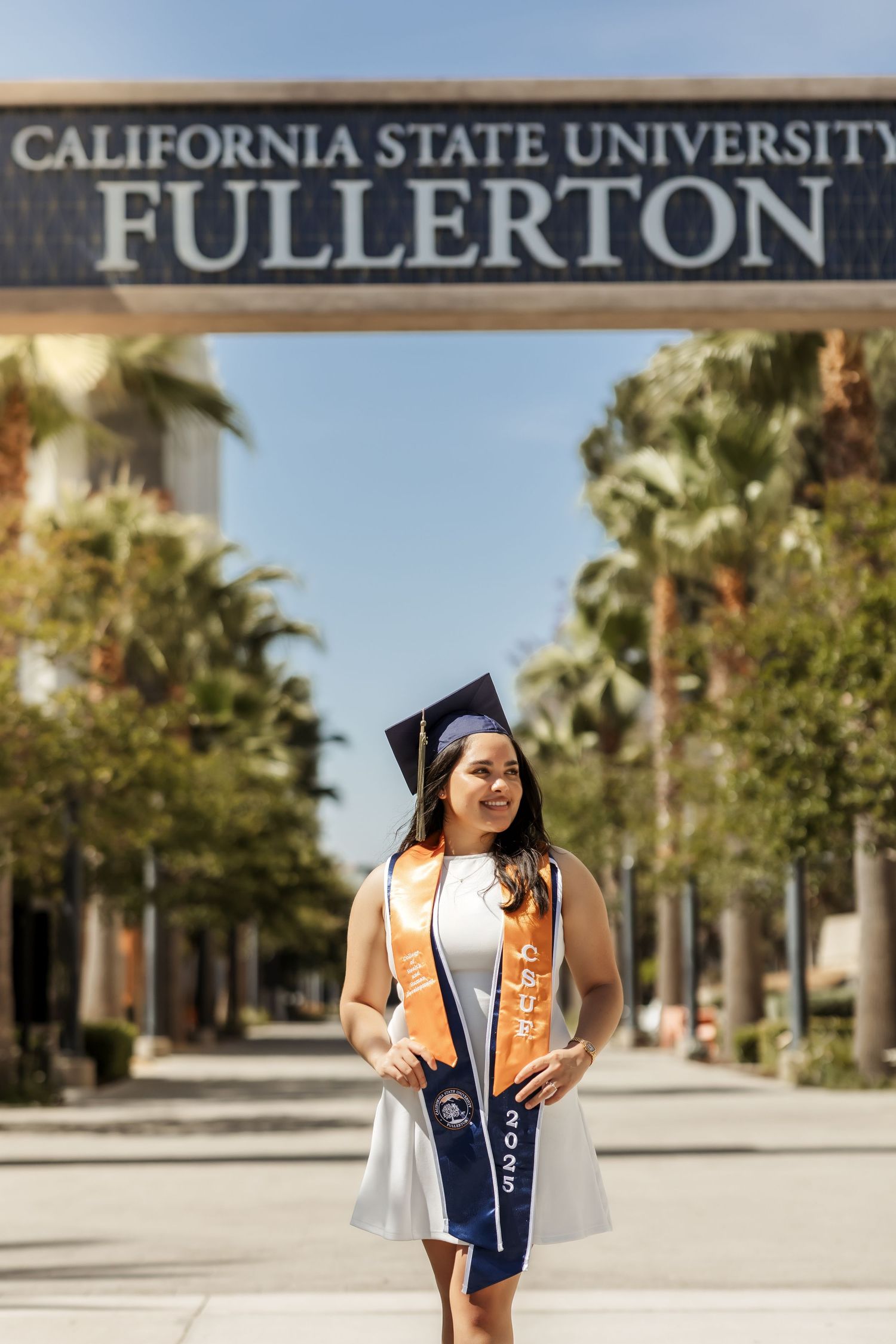 College grad with cap and sashes during a grad portrait session at Cal State Fullerton, CA
