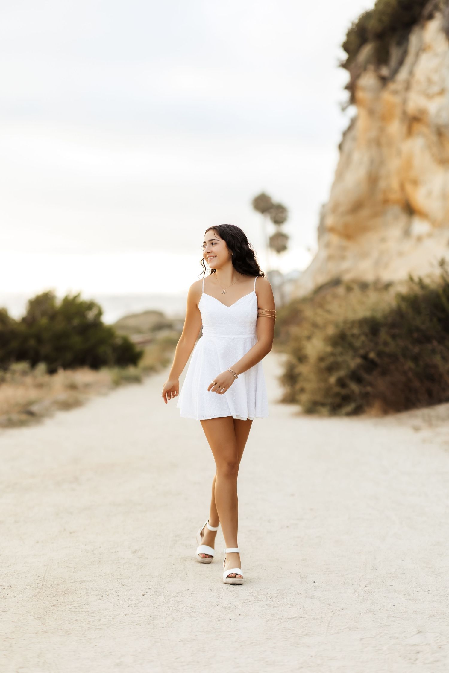 Grad walking along a trail at the beach in San Clemente, CA