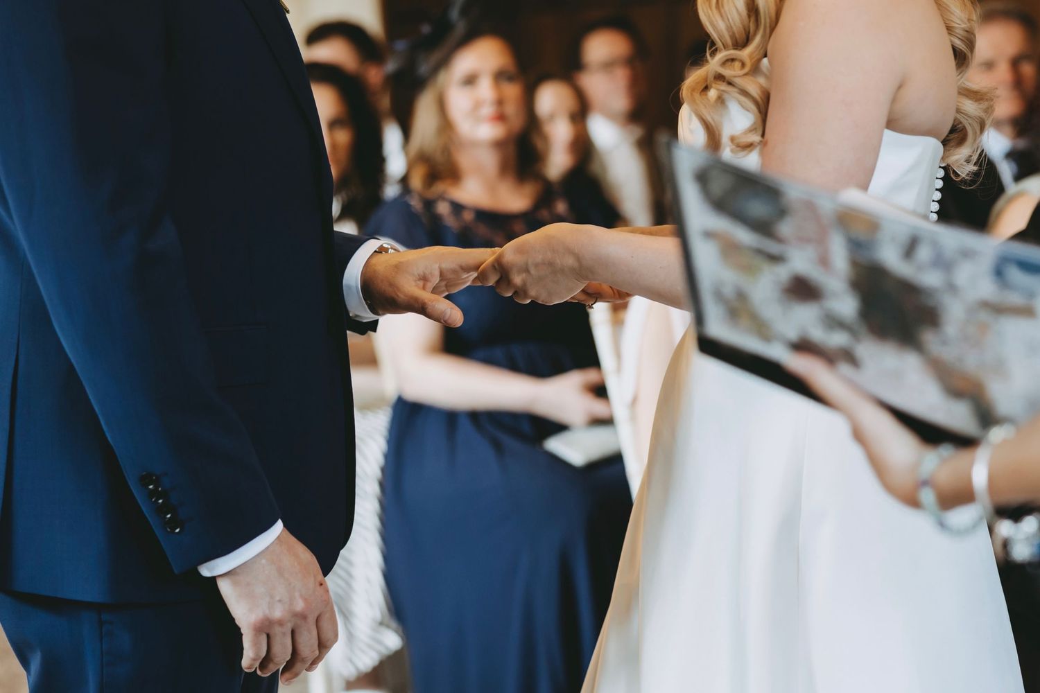 Couple in navy and white exchange rings during intimate ceremony.