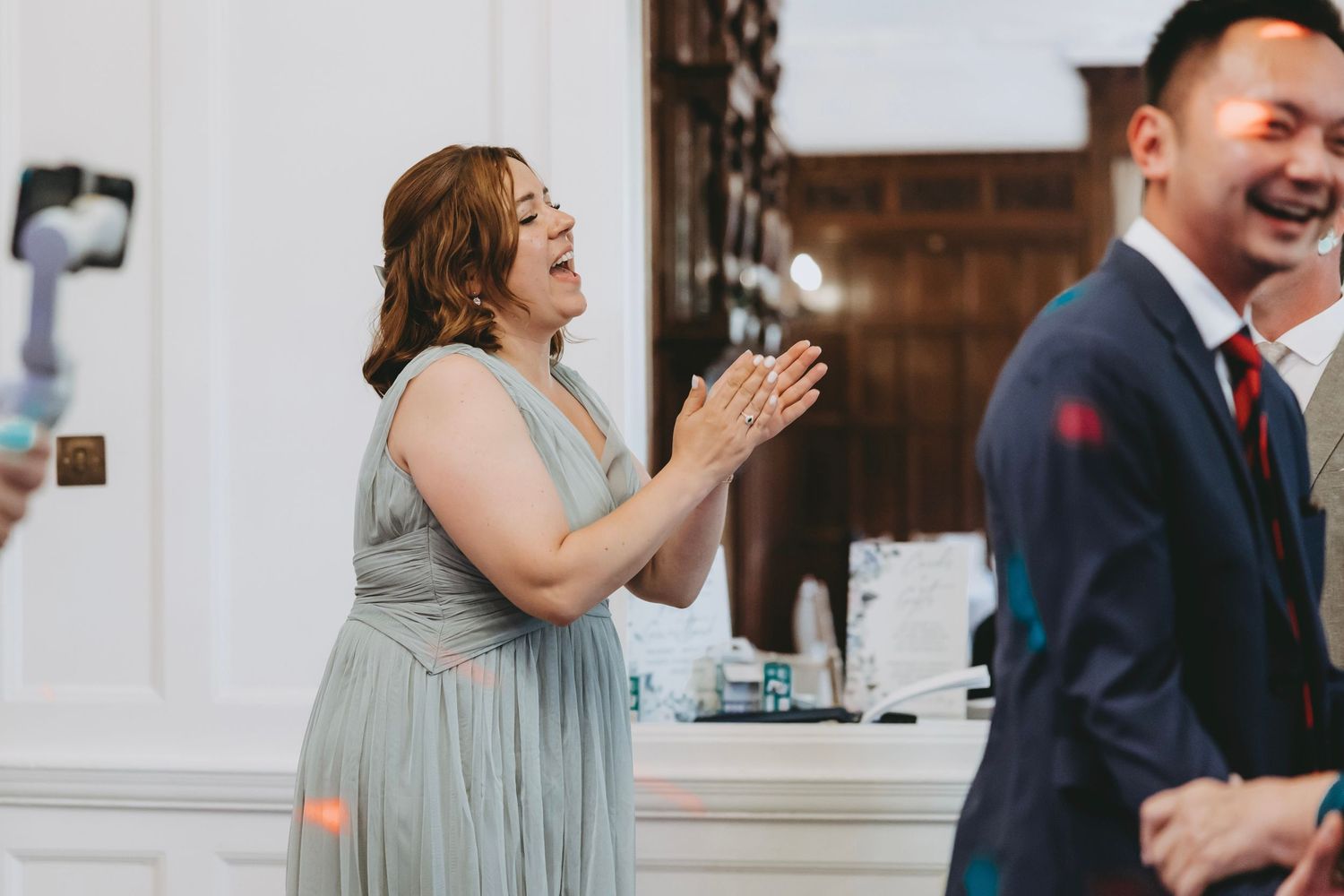 Guests enjoying themselves at a formal celebration in a bright indoor space.