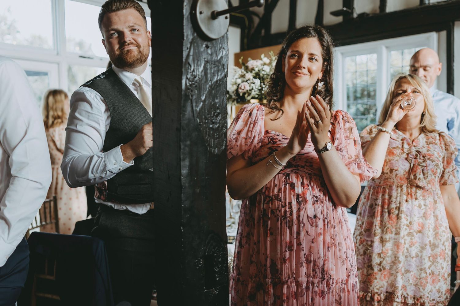 Wedding party members listen attentively during reception speeches.