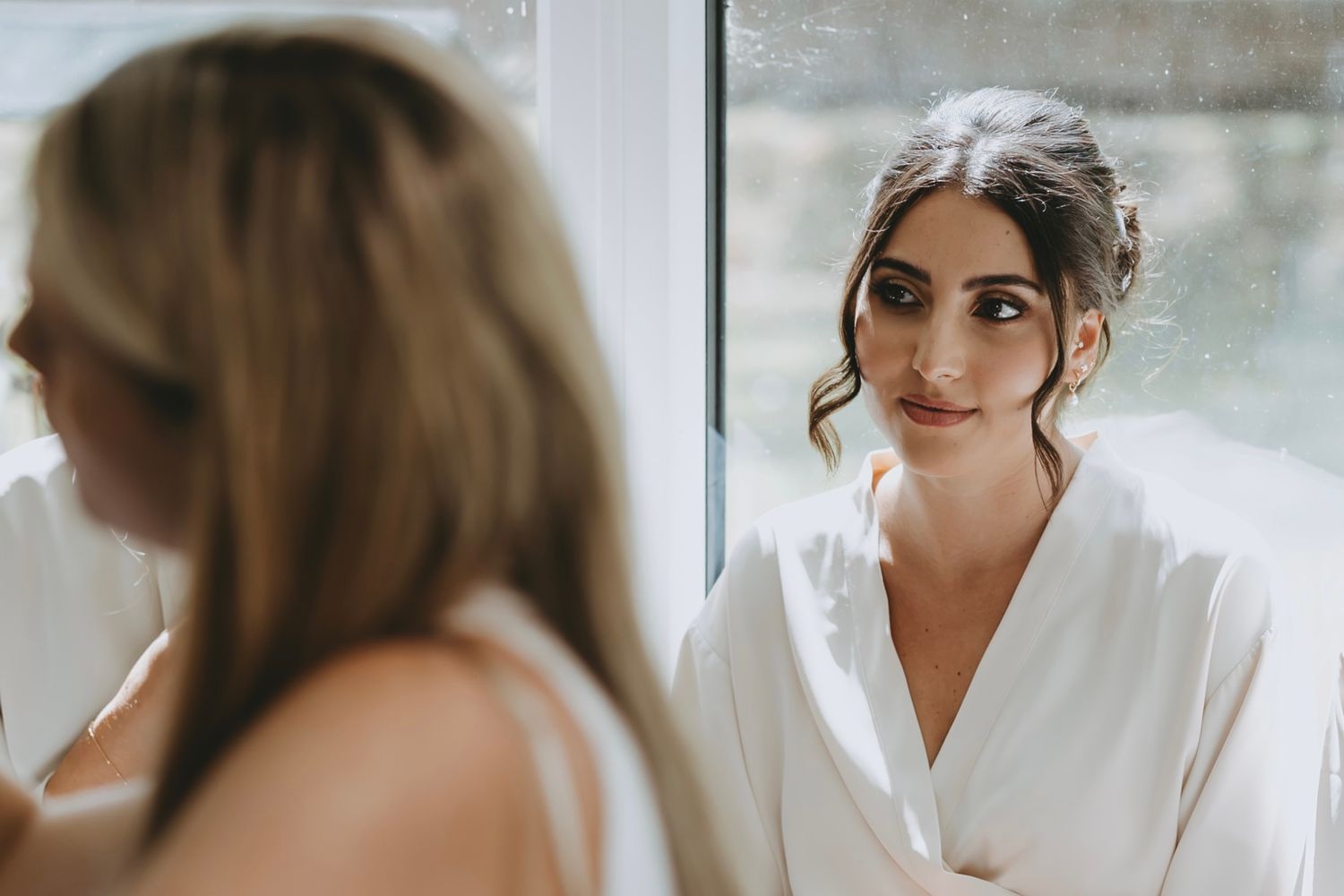 Group of women in white robes getting ready in bright modern space.