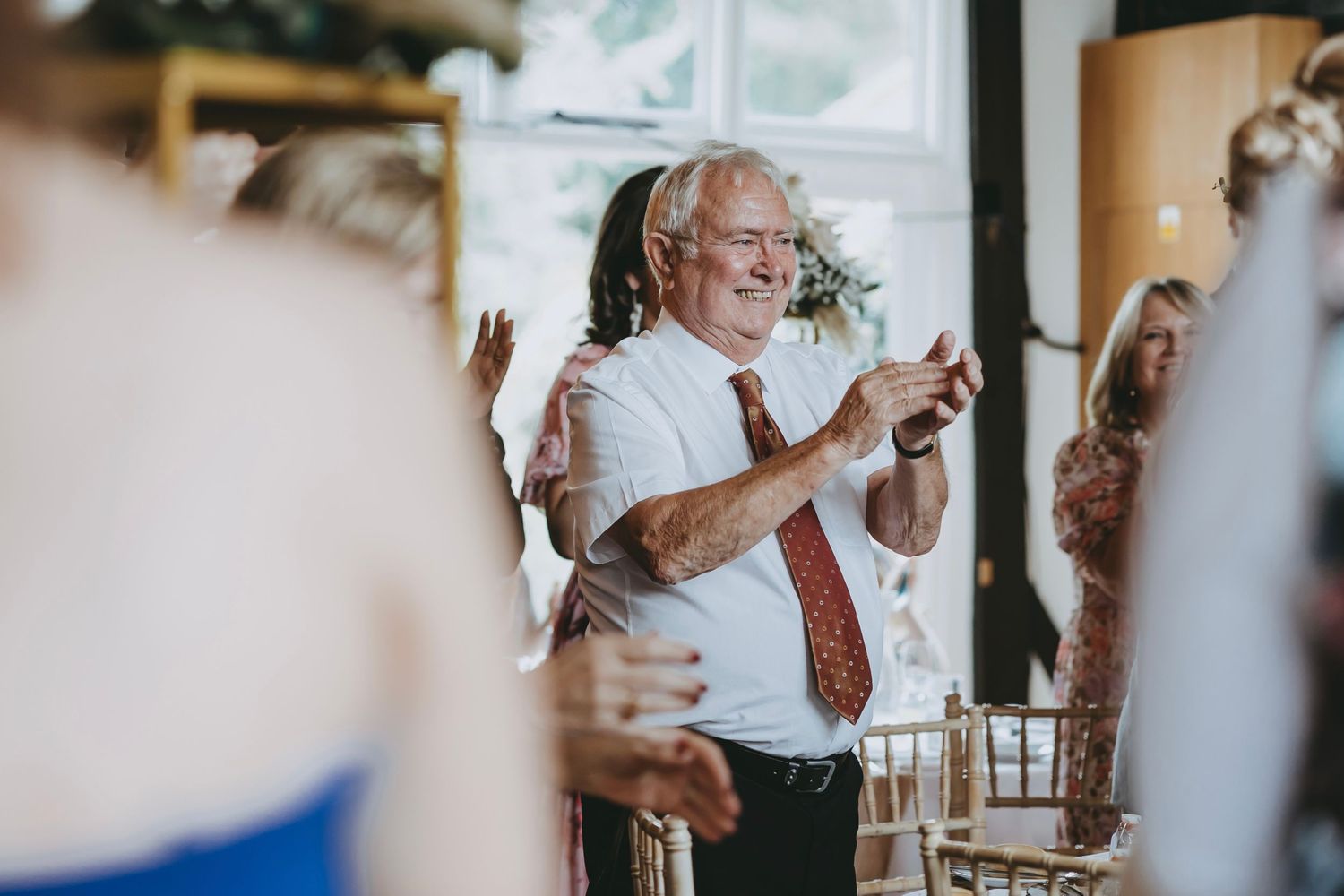 Wedding reception guests enjoying drinks and conversation indoors.