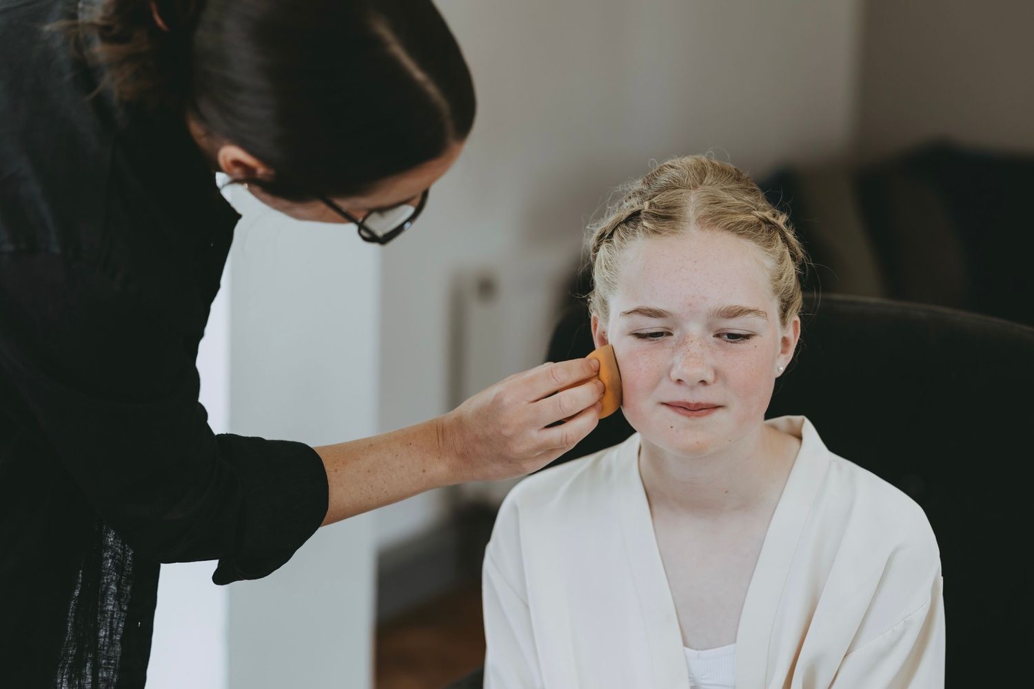 Gentle application of makeup during wedding day preparations.