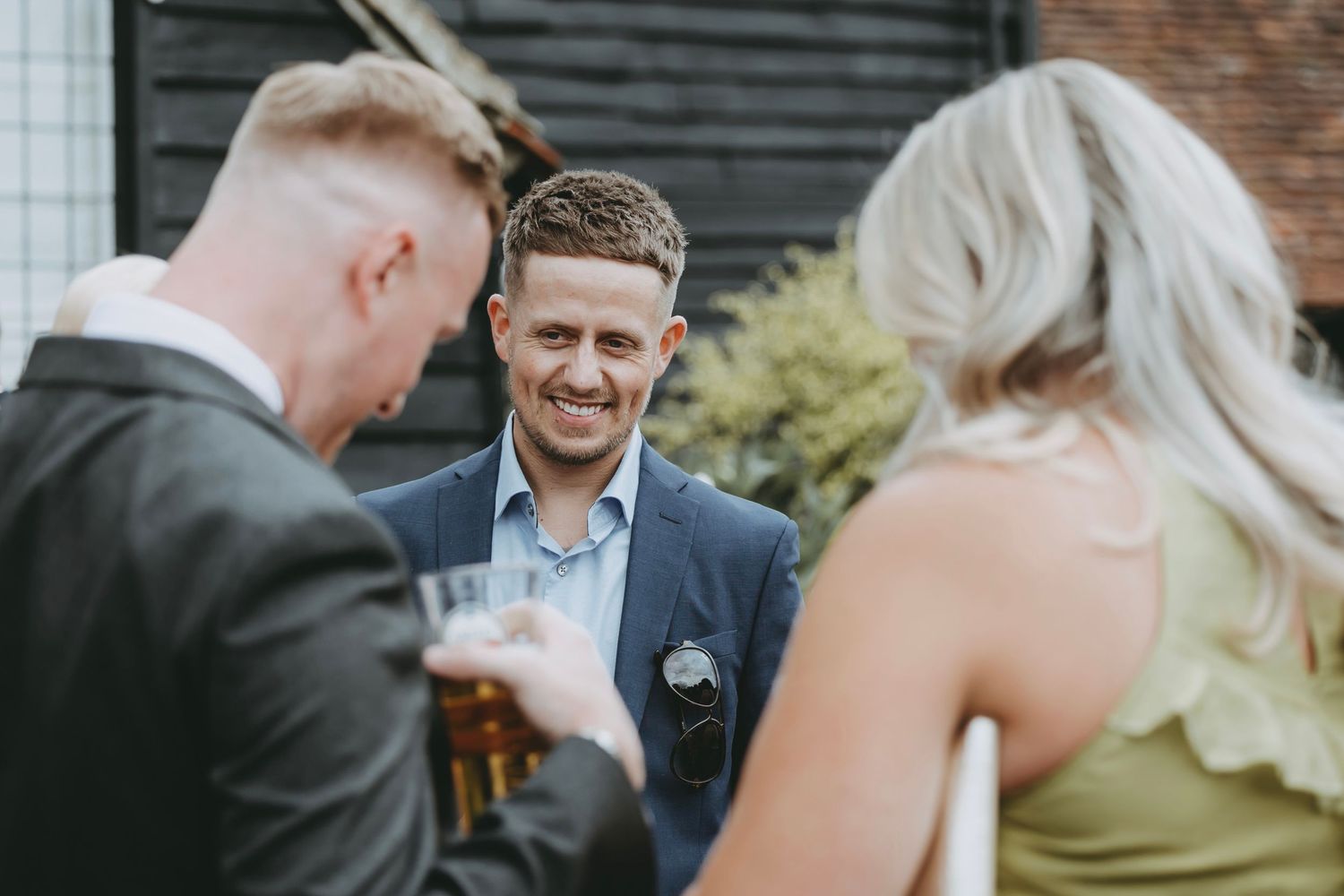 Wedding guests chatting and mingling during an outdoor cocktail reception.