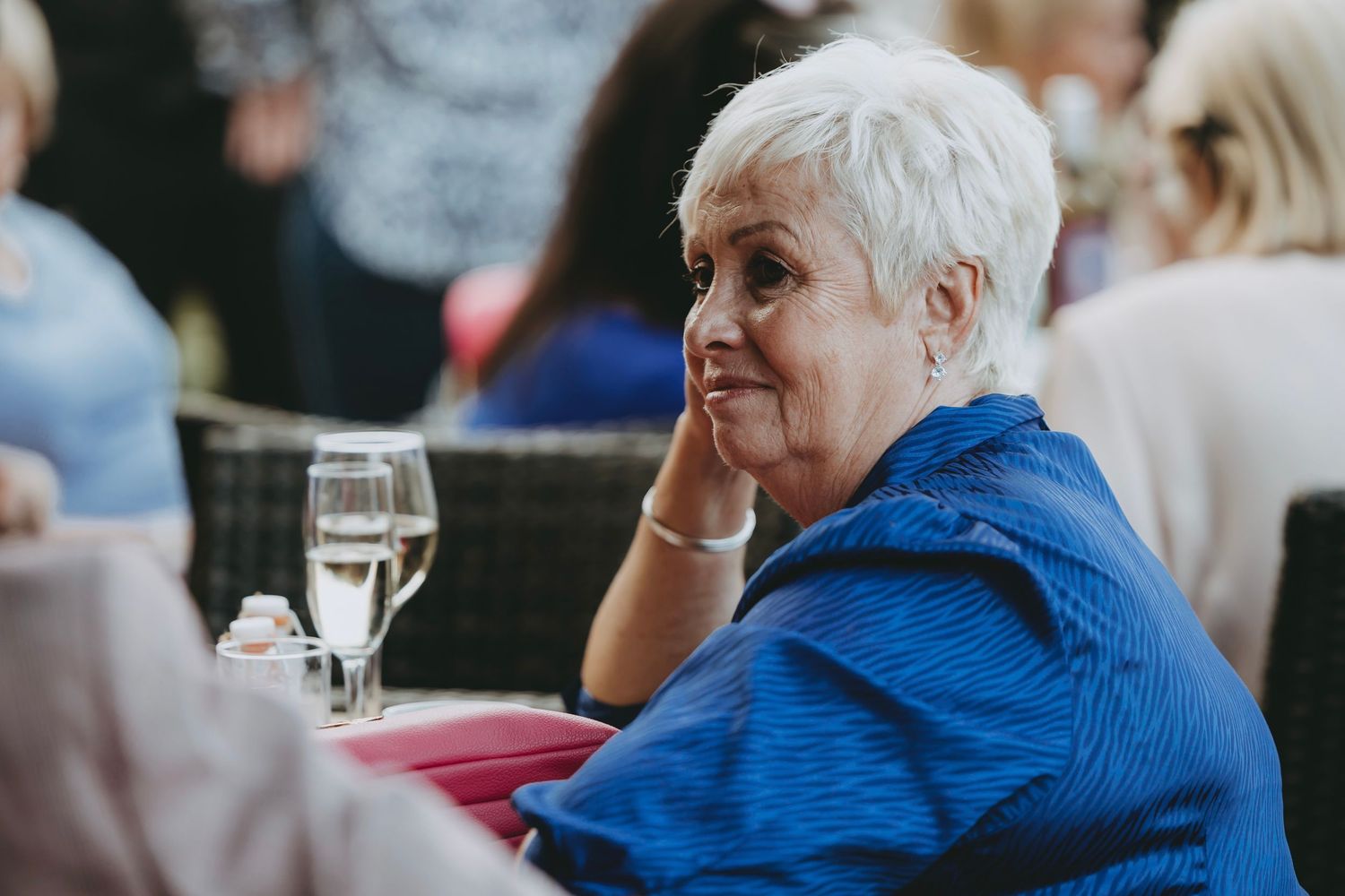 Guests seated at tables during an outdoor event with natural lighting.
