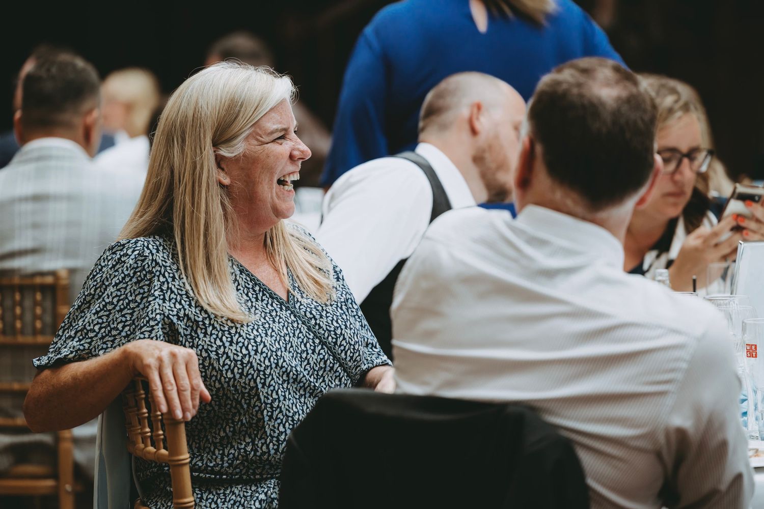 Wedding guests enjoying a lively conversation at an elegant reception dinner.