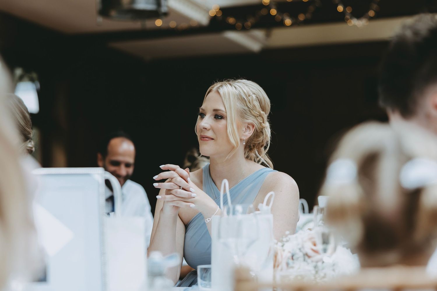 Wedding reception guests mingling at elegantly set dining tables.