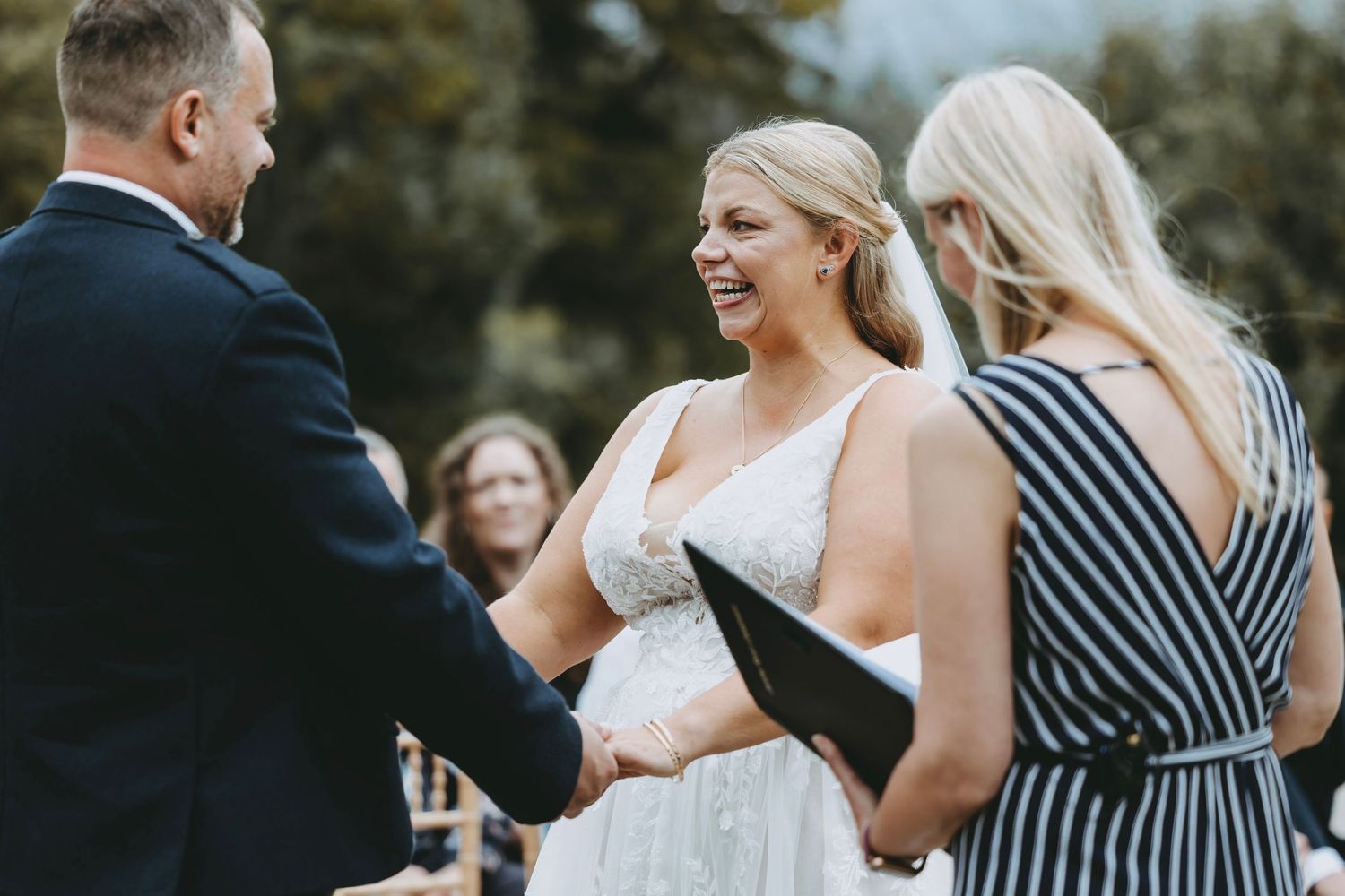 Wedding celebration with guests in formal wear mingling during outdoor reception.