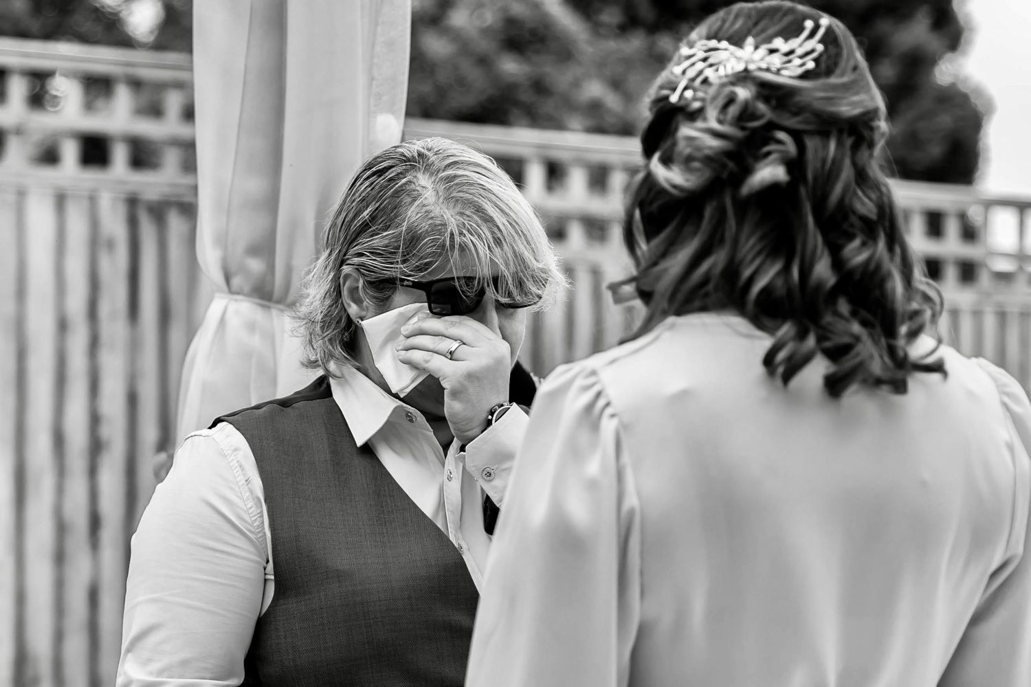 Wedding guests mingling on an outdoor patio during a daytime reception.