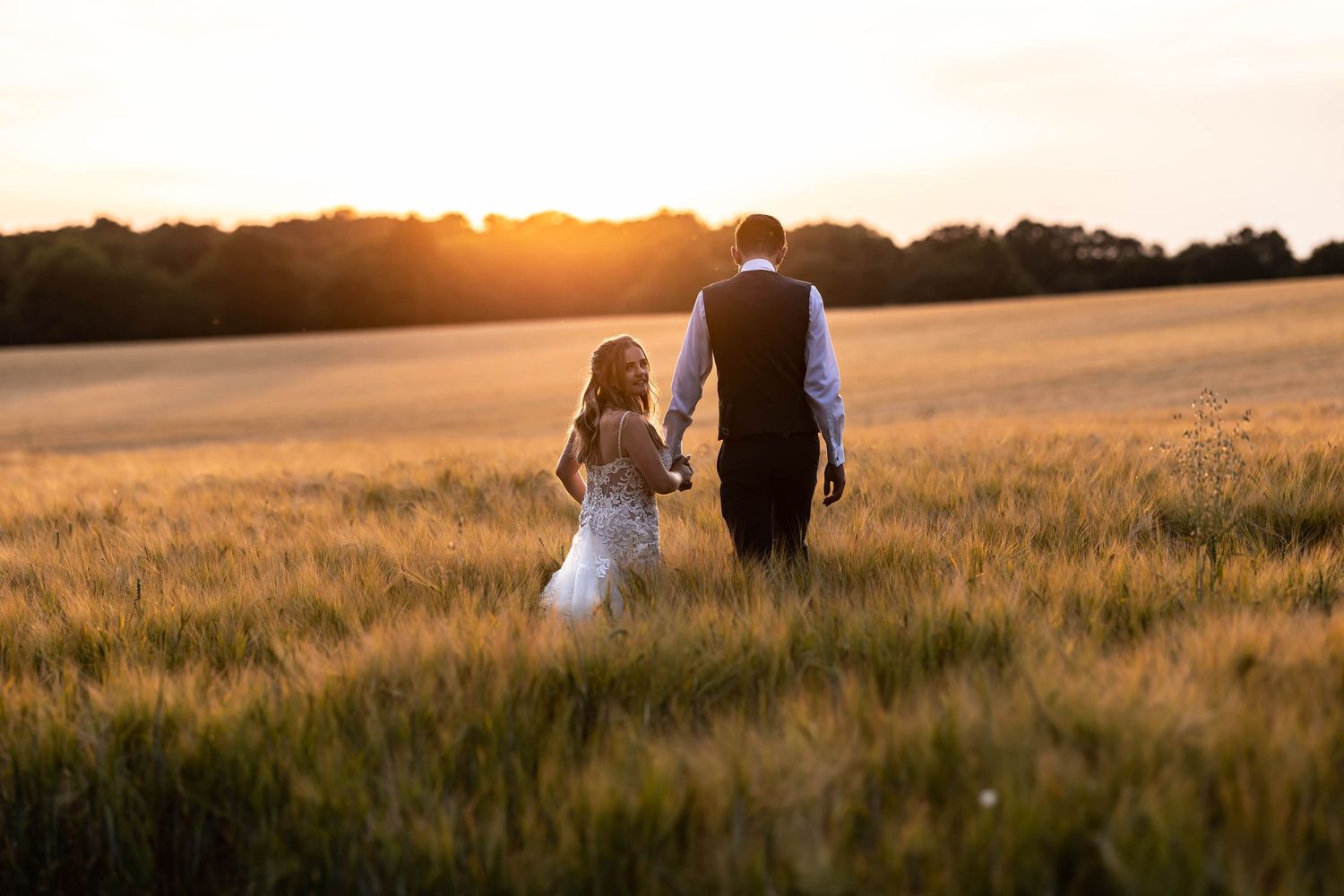 Romantic sunset portrait in a golden wheat field with warm lighting.