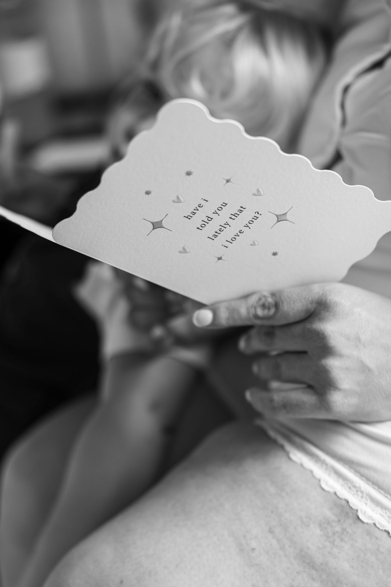 A close-up view of decorative paper cards with scalloped edges being held.