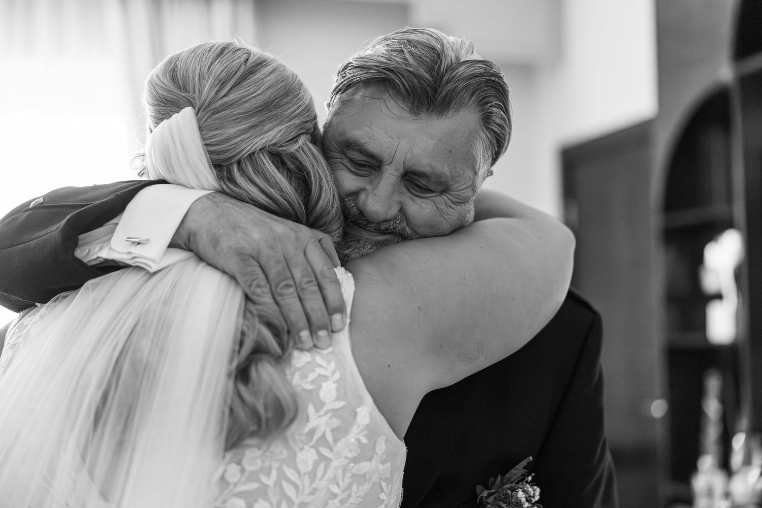 Black and white emotional moment during wedding preparations.