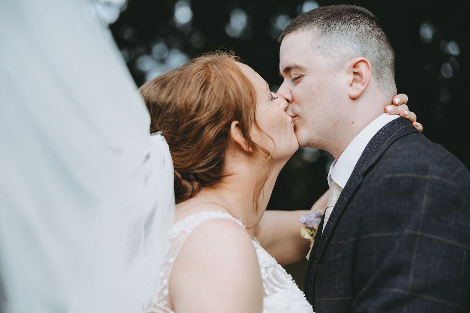 A bride and groom share a romantic kiss.