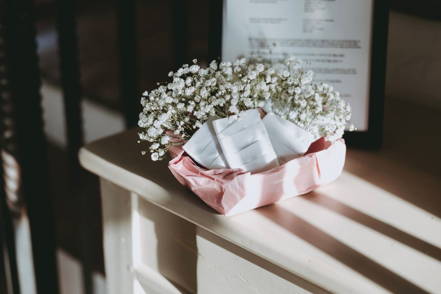 White floral arrangements with baby's breath decorate wedding tables in an elegant reception hall.