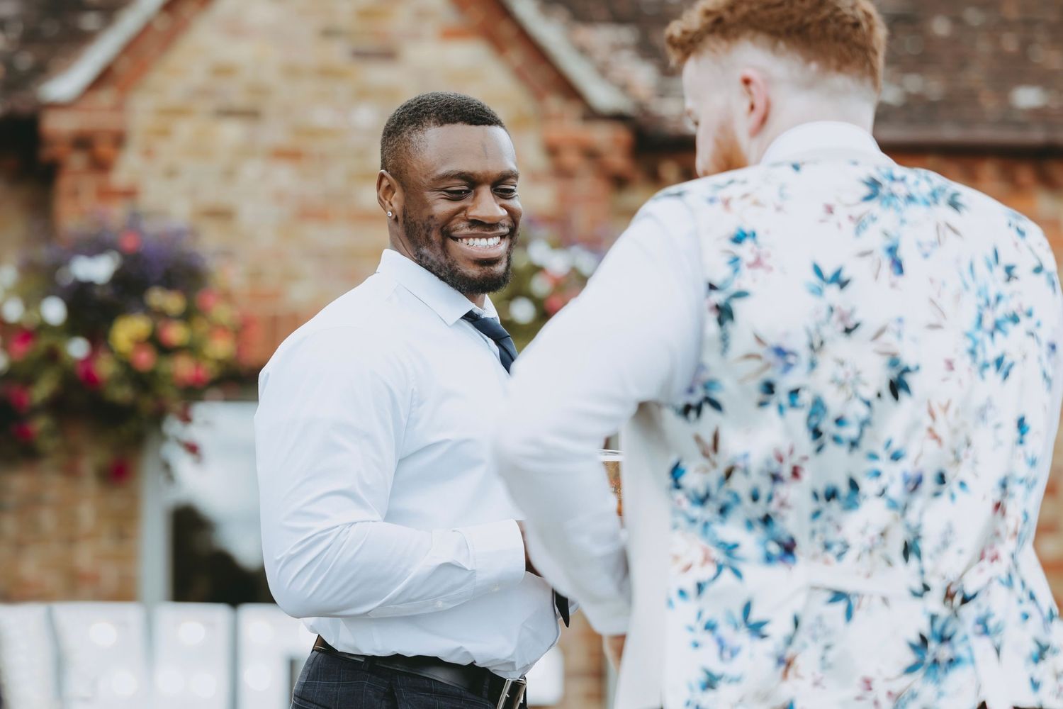 Wedding guests mingling and laughing during outdoor reception celebration.