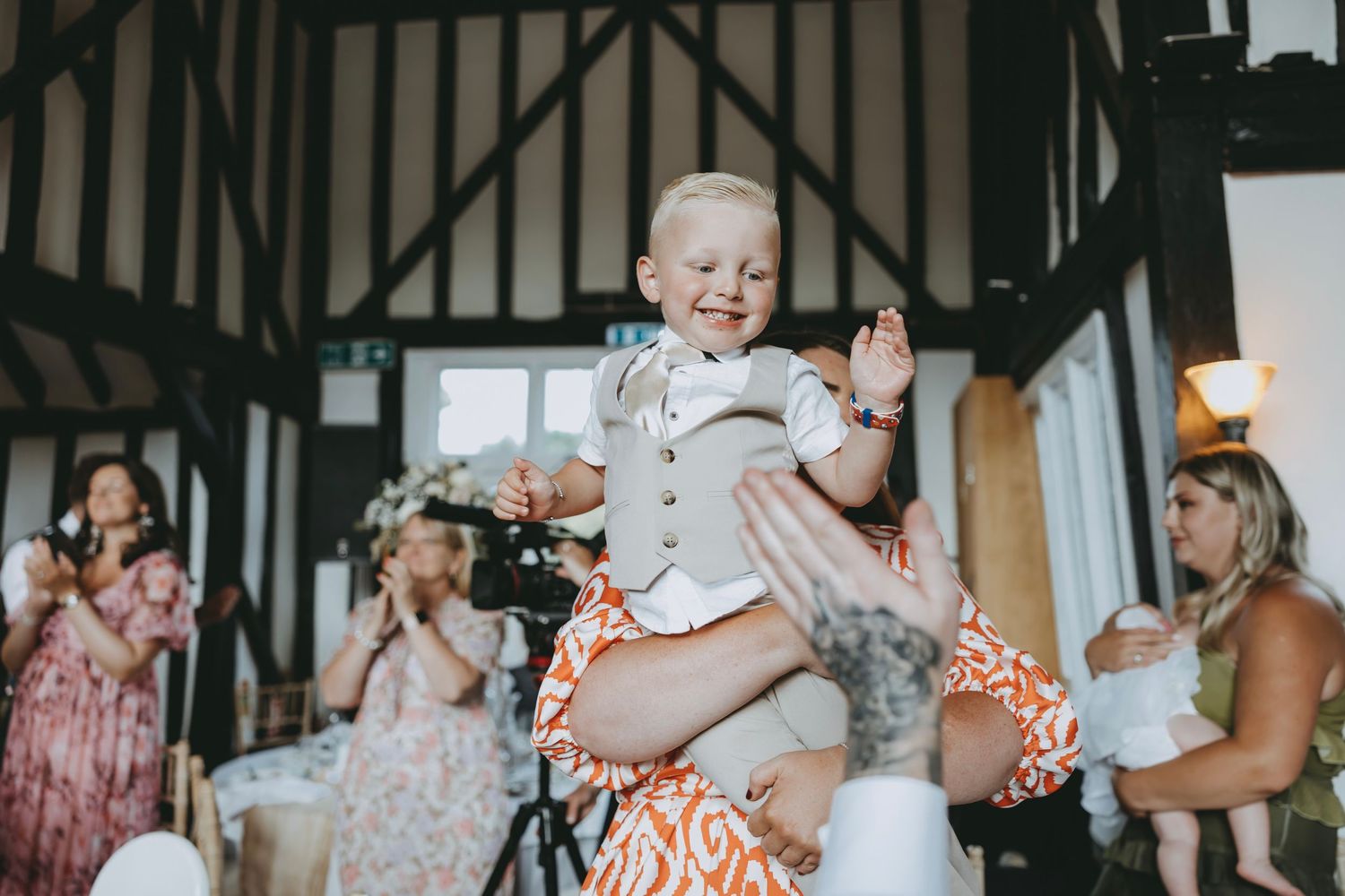 Guests share joyful moments during a wedding celebration in a rustic indoor setting.