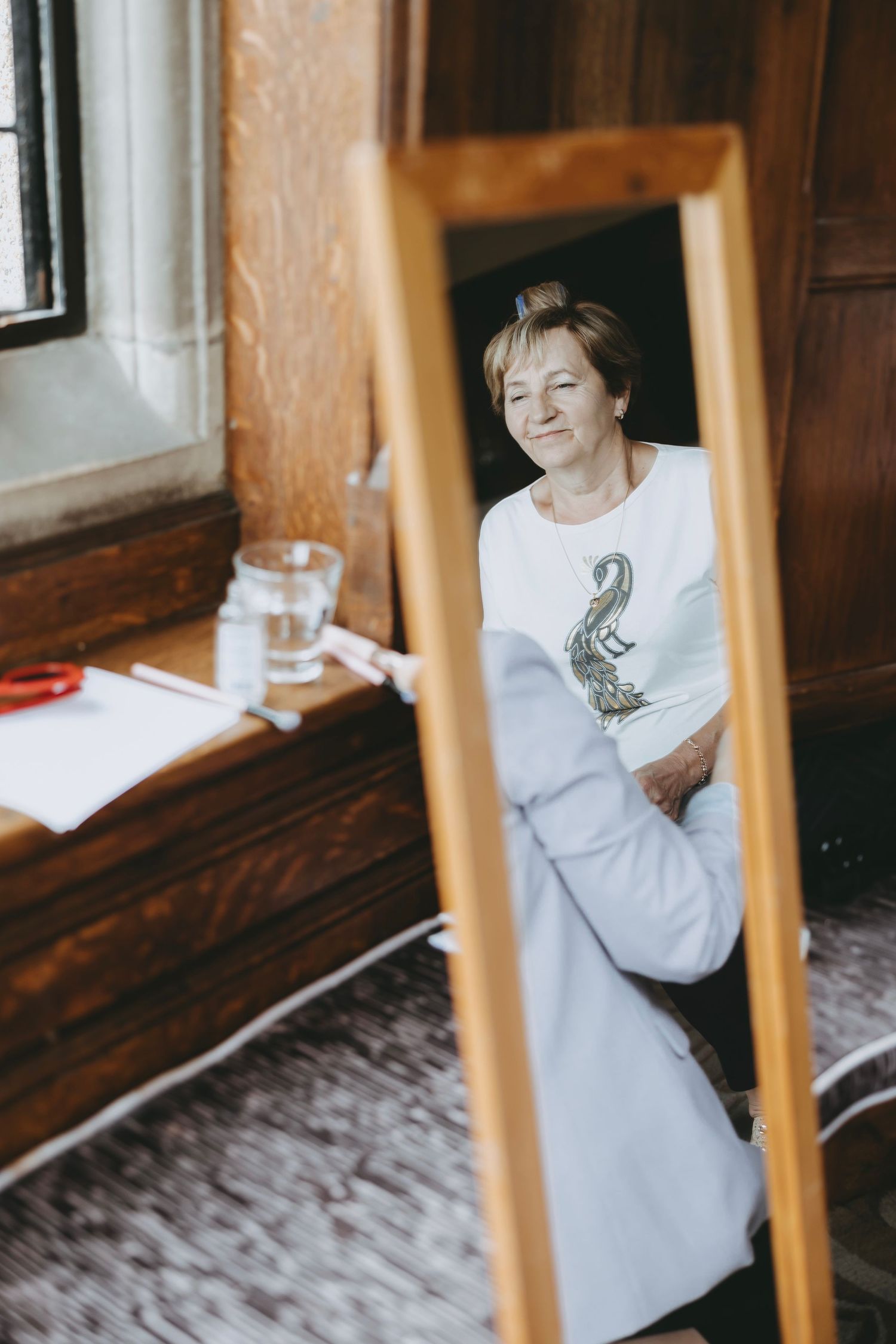 Casual moment captured through mirror reflection during wedding preparations.