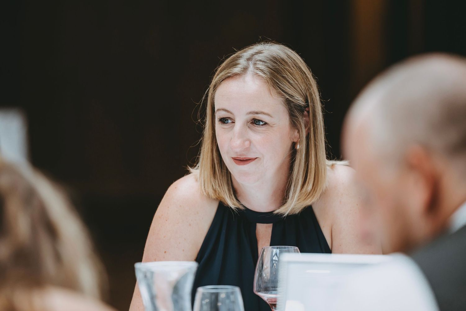 Guests engaged in conversation at a formal dining event.