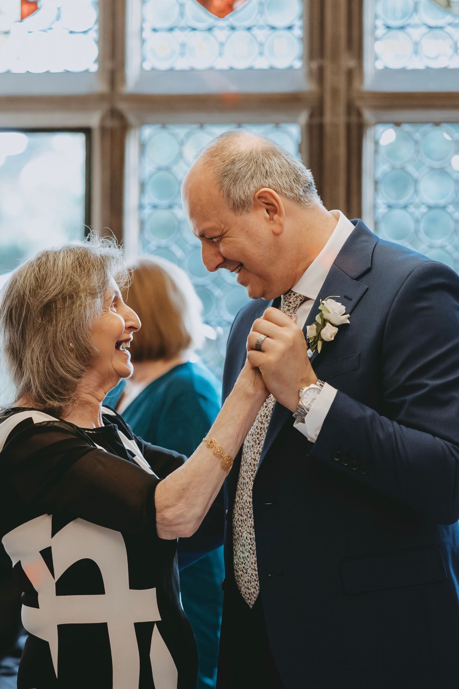 Couples dancing together at an elegant event on a black and white checkered floor.