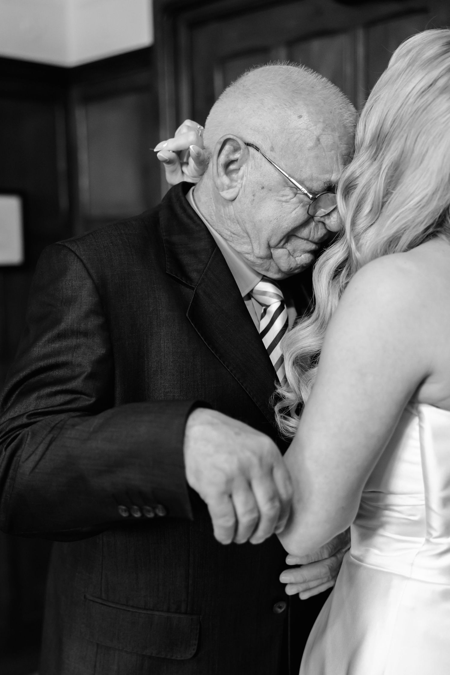 Black and white emotional wedding moment captured in an intimate indoor setting.