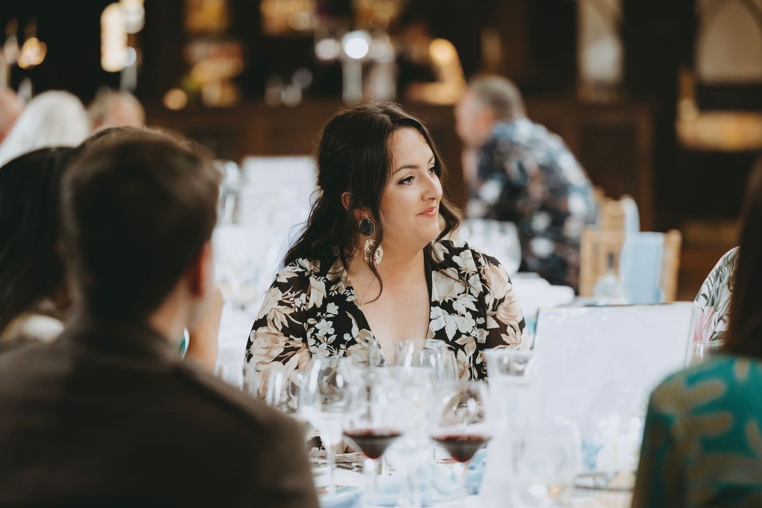 Wedding reception table settings with wine glasses and soft lighting create an intimate atmosphere.