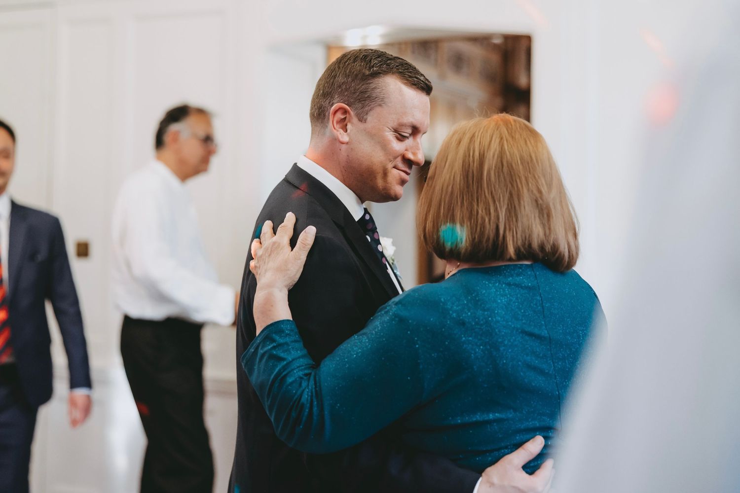 Couples dancing together at an elegant indoor wedding reception with ambient lighting.