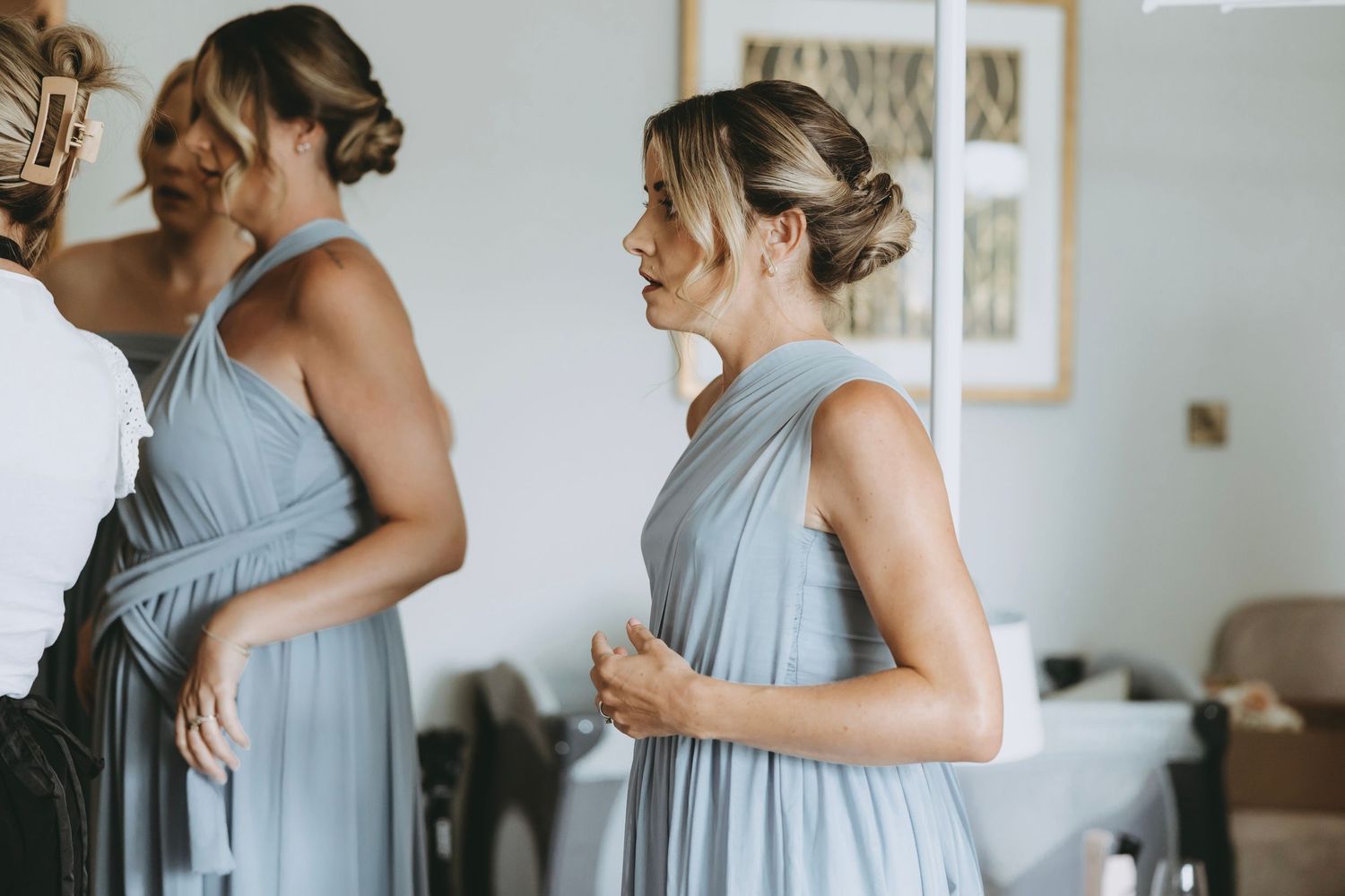 Women in matching light blue bridesmaid dresses getting ready.