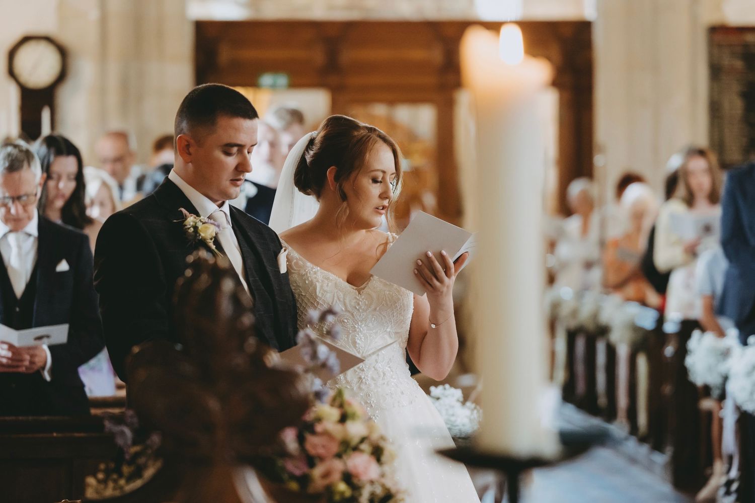 Interior of historic church decorated for wedding ceremony with wooden pews and soft lighting.