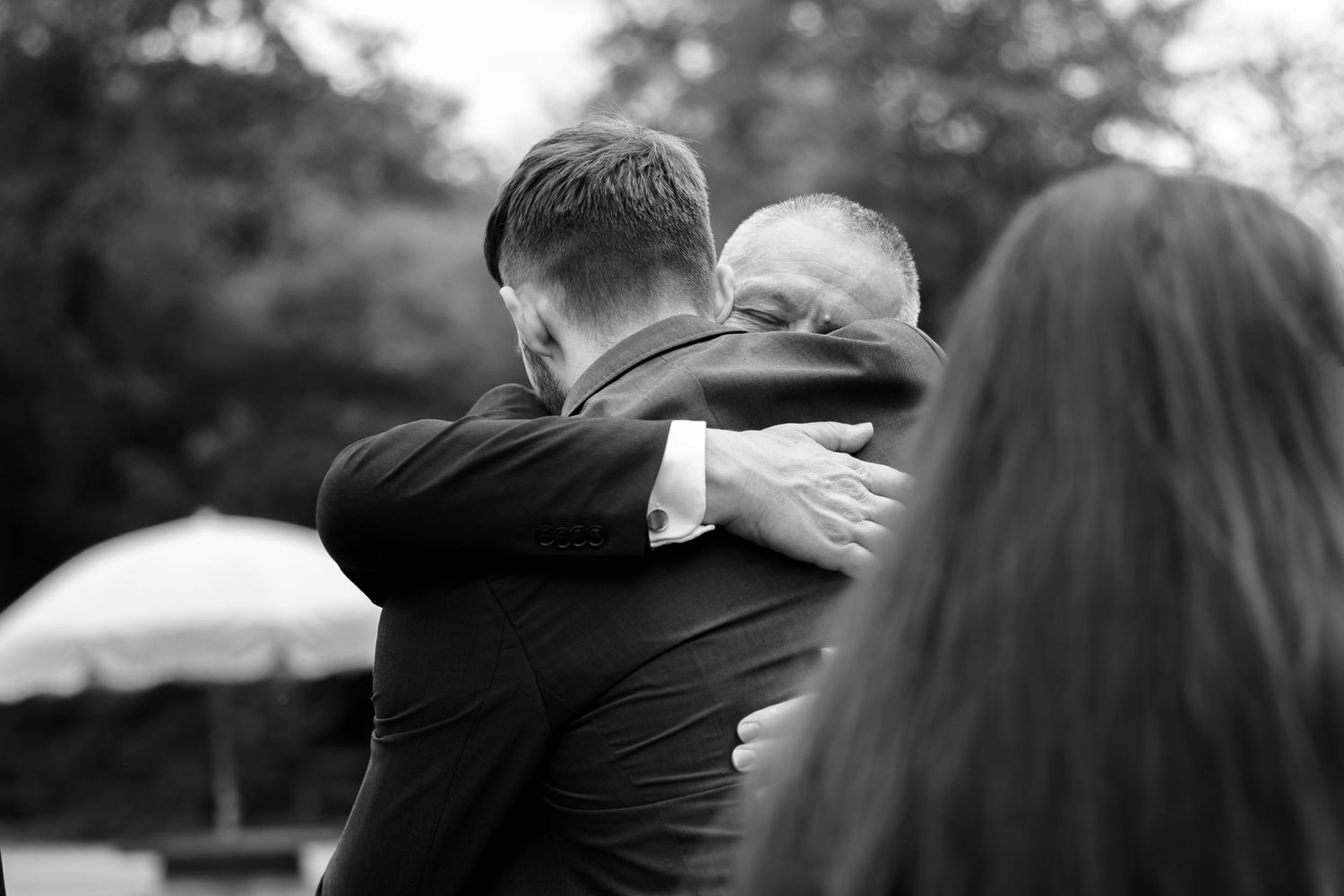 Black and white emotional moment captured during outdoor wedding celebration.