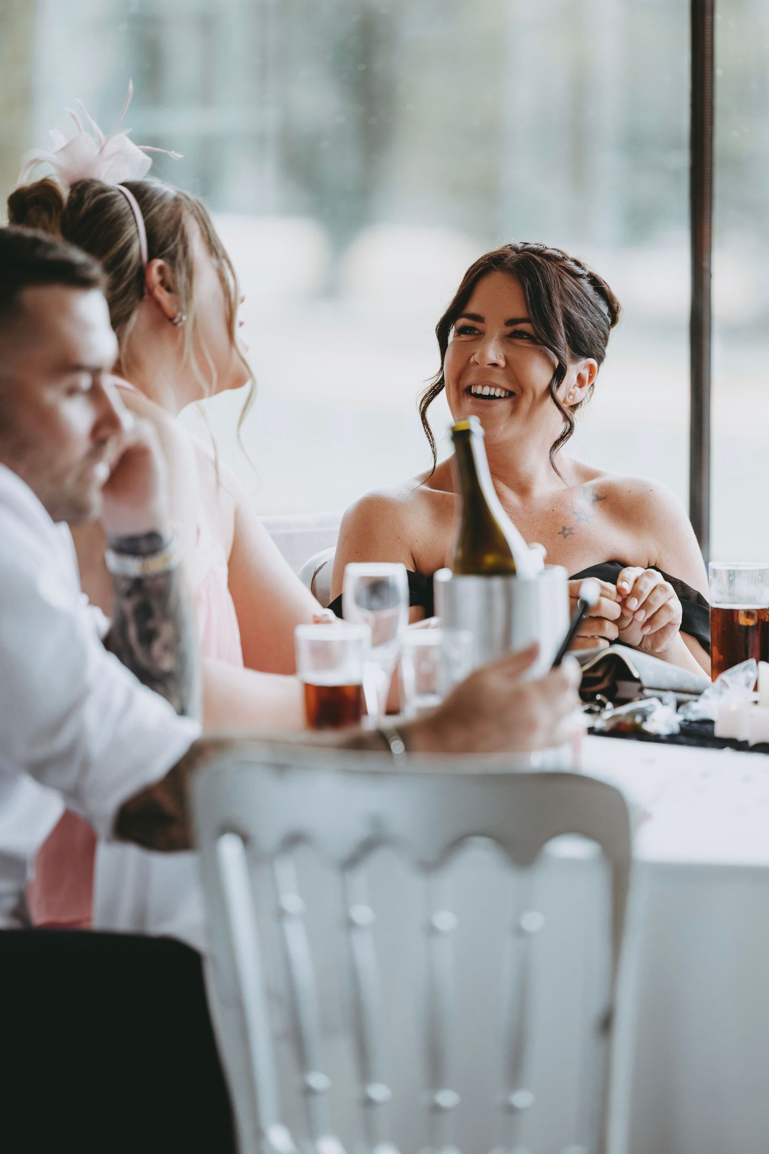 Candid moment of joyful laughter shared during a wedding reception dinner.