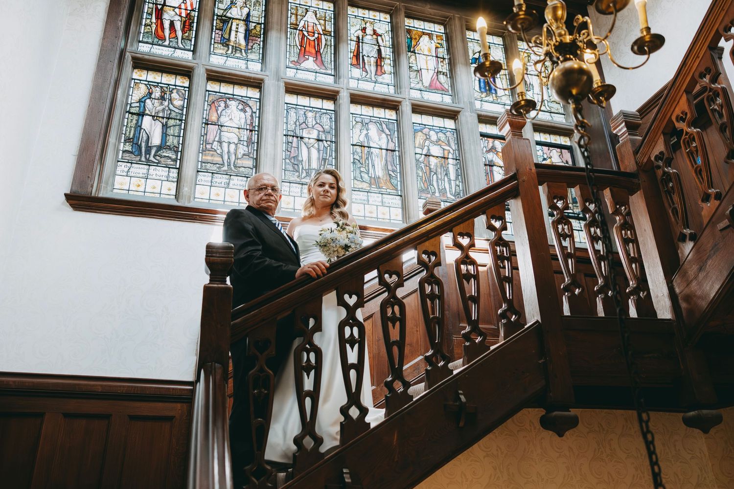 Ornate stained glass windows and wooden details in a historic wedding venue interior.