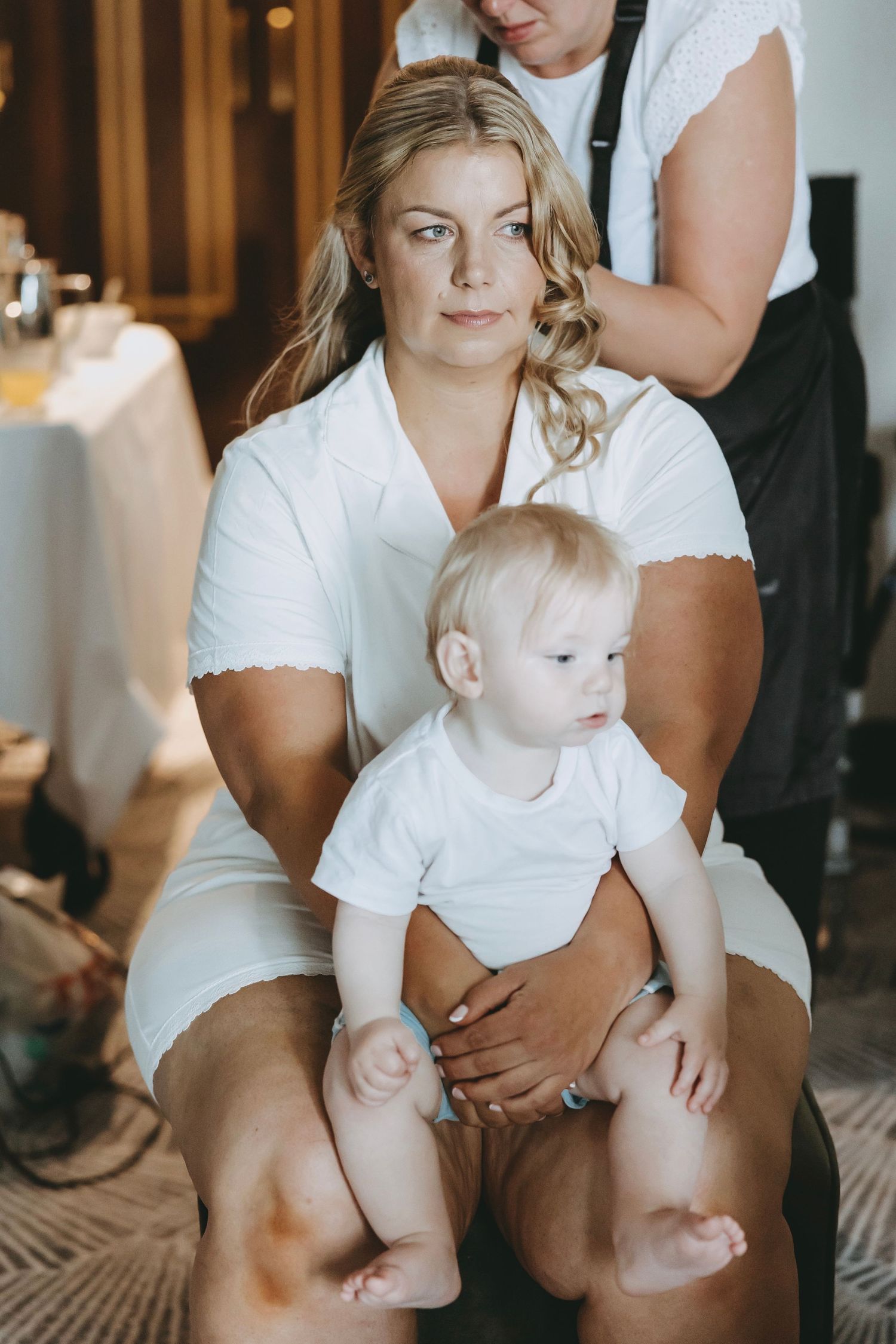 Intimate wedding preparation moments captured in natural light with white attire.
