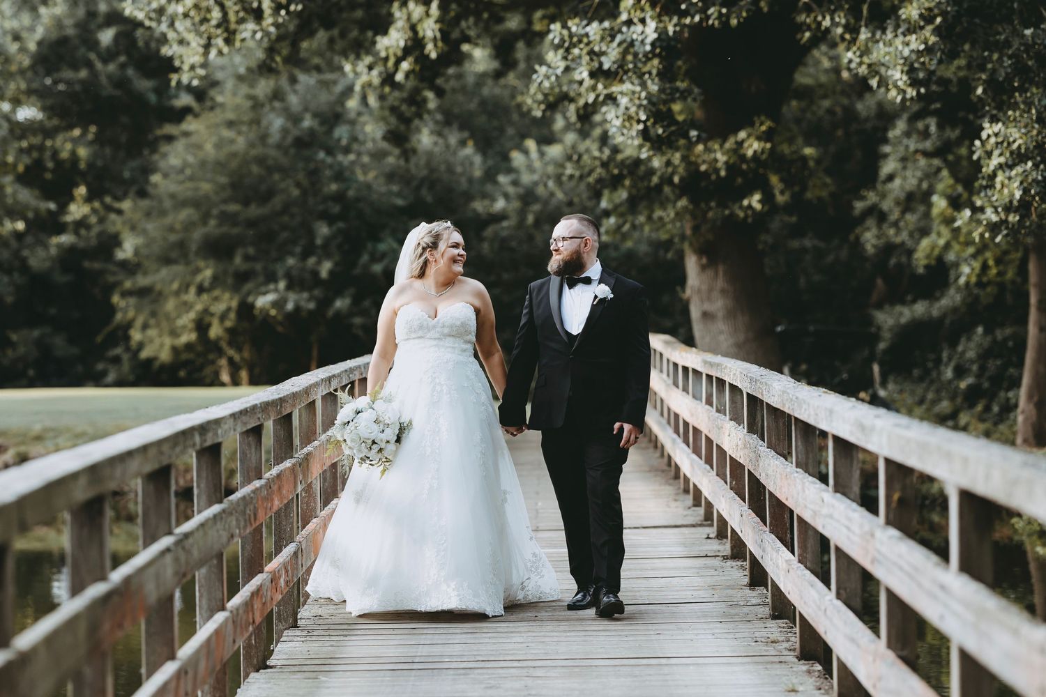 Romantic wedding photography sequence on a wooden bridge in a natural setting at Essendon Golf Club, Hertfordshire.