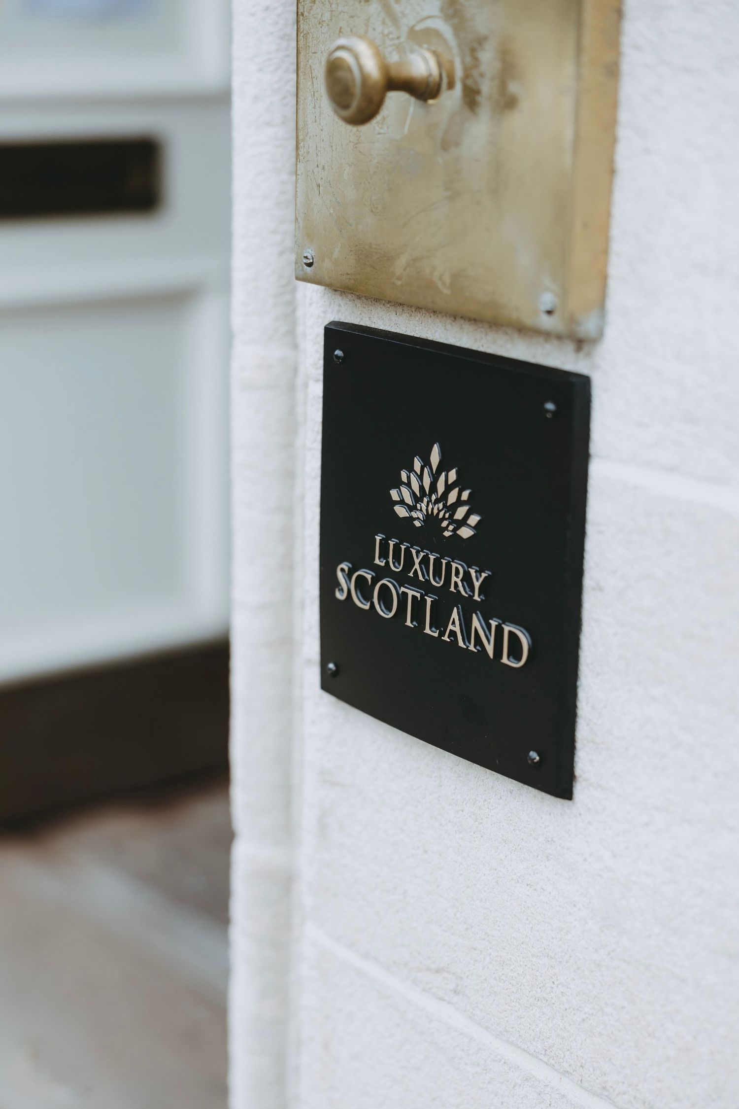 Luxury Scotland signage mounted on white wall of upscale establishment.