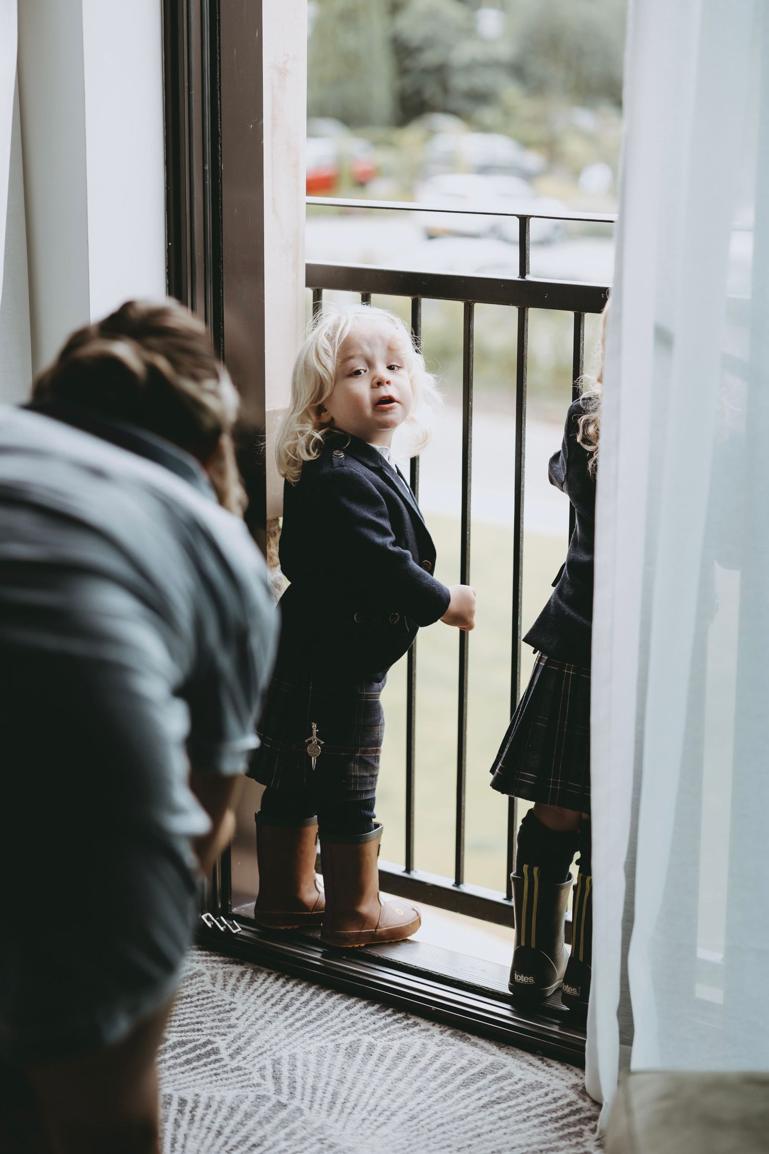 Child in dark clothing peering through window bars in a sequence of photos.