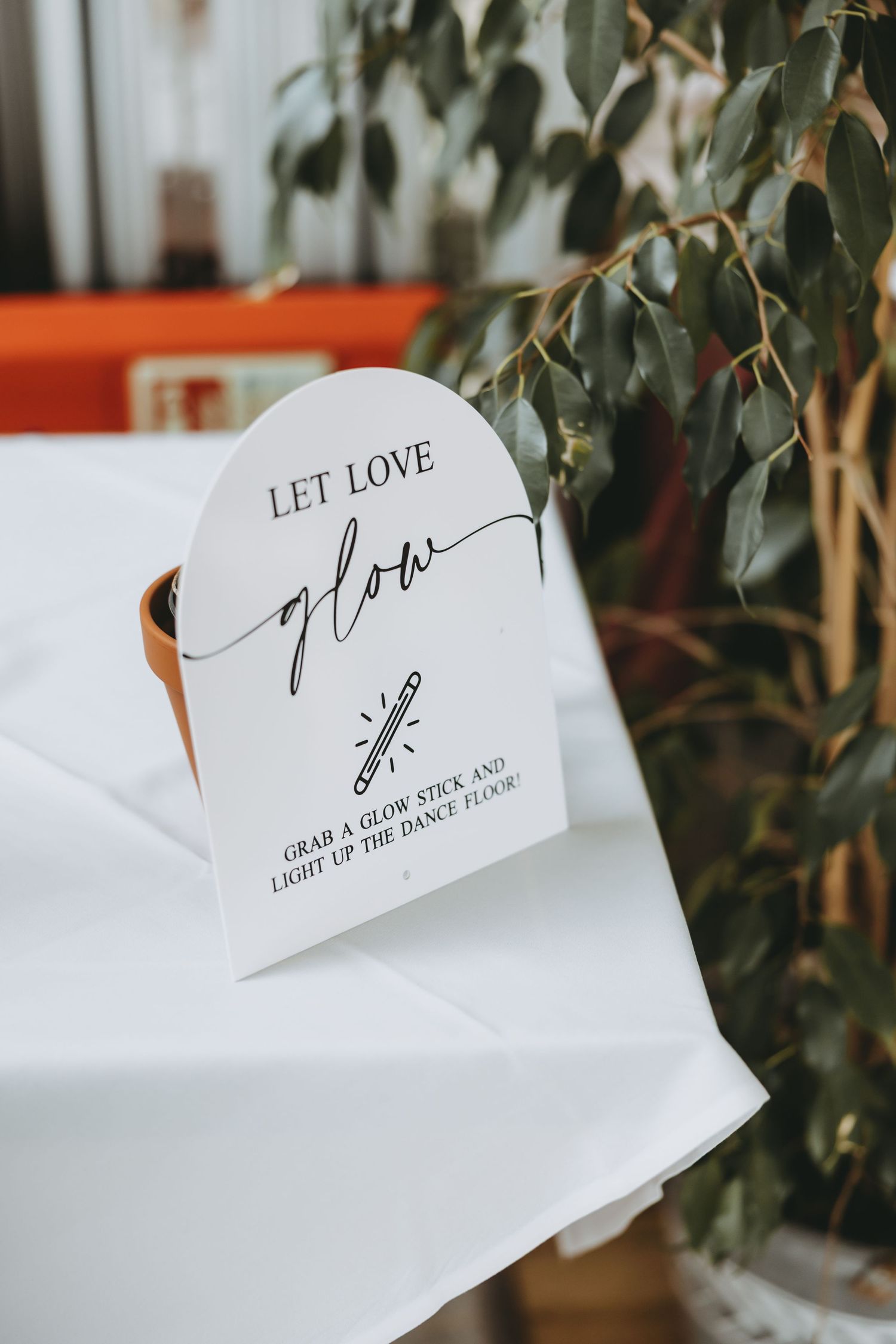 Wedding stationery with 'Let Love' calligraphy text against white background.