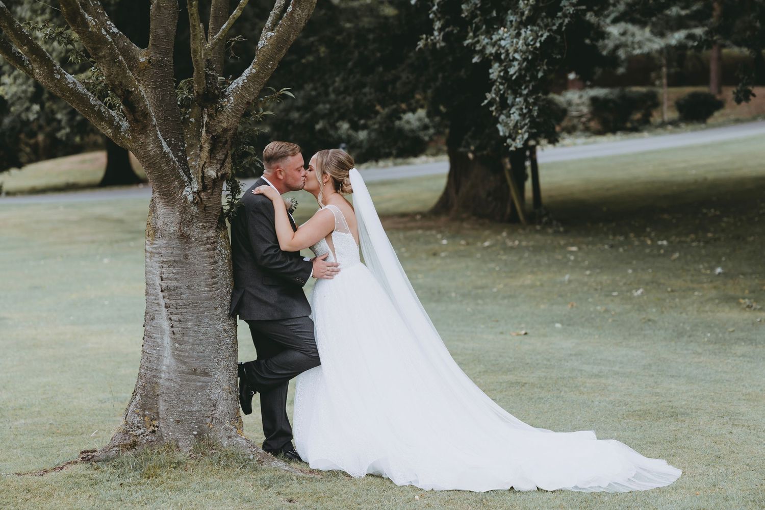 Bride and groom share romantic dance moment in outdoor garden setting.