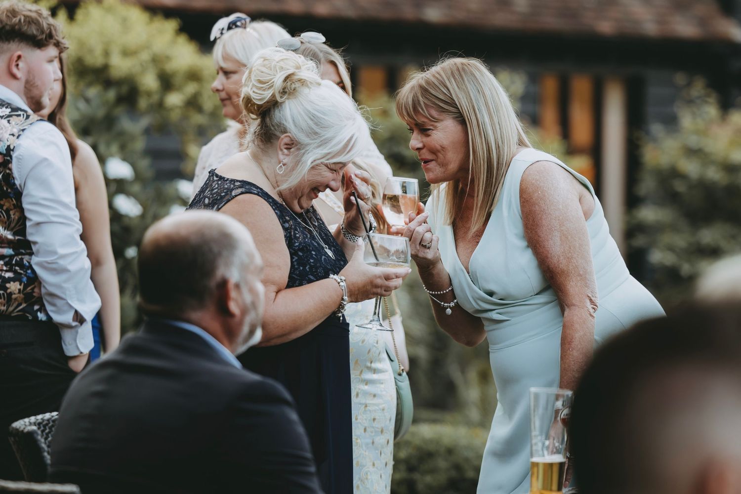 Wedding attendees mingle and socialize during an outdoor garden reception.