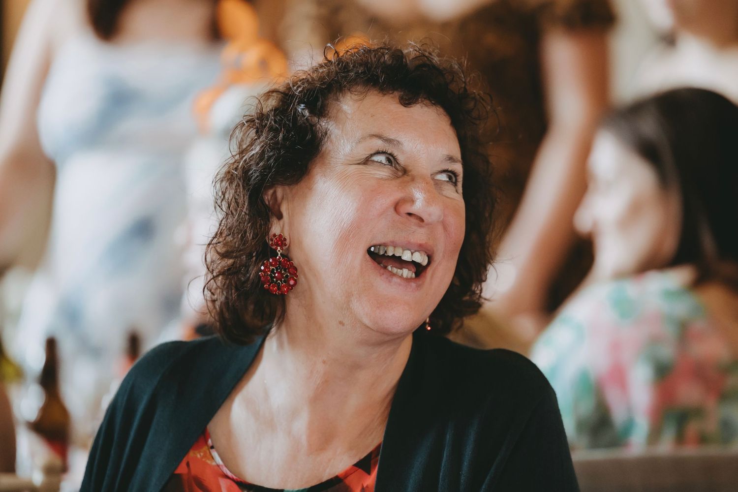 Candid moment of guests laughing during wedding reception.