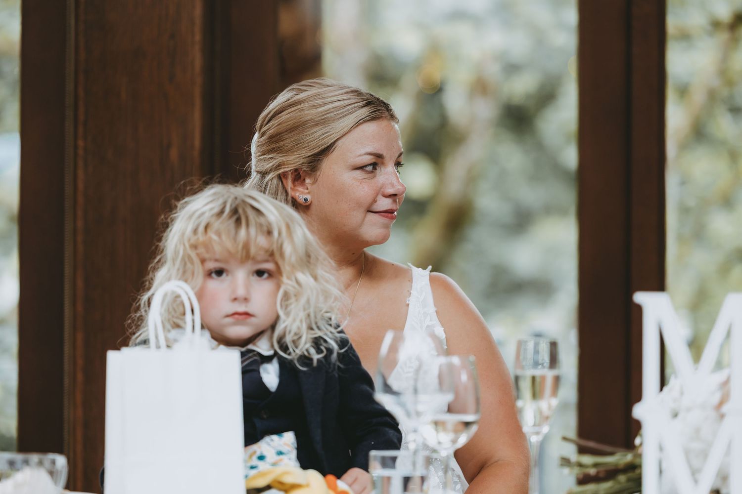Wedding reception venue with elegant table settings and natural light from large windows.