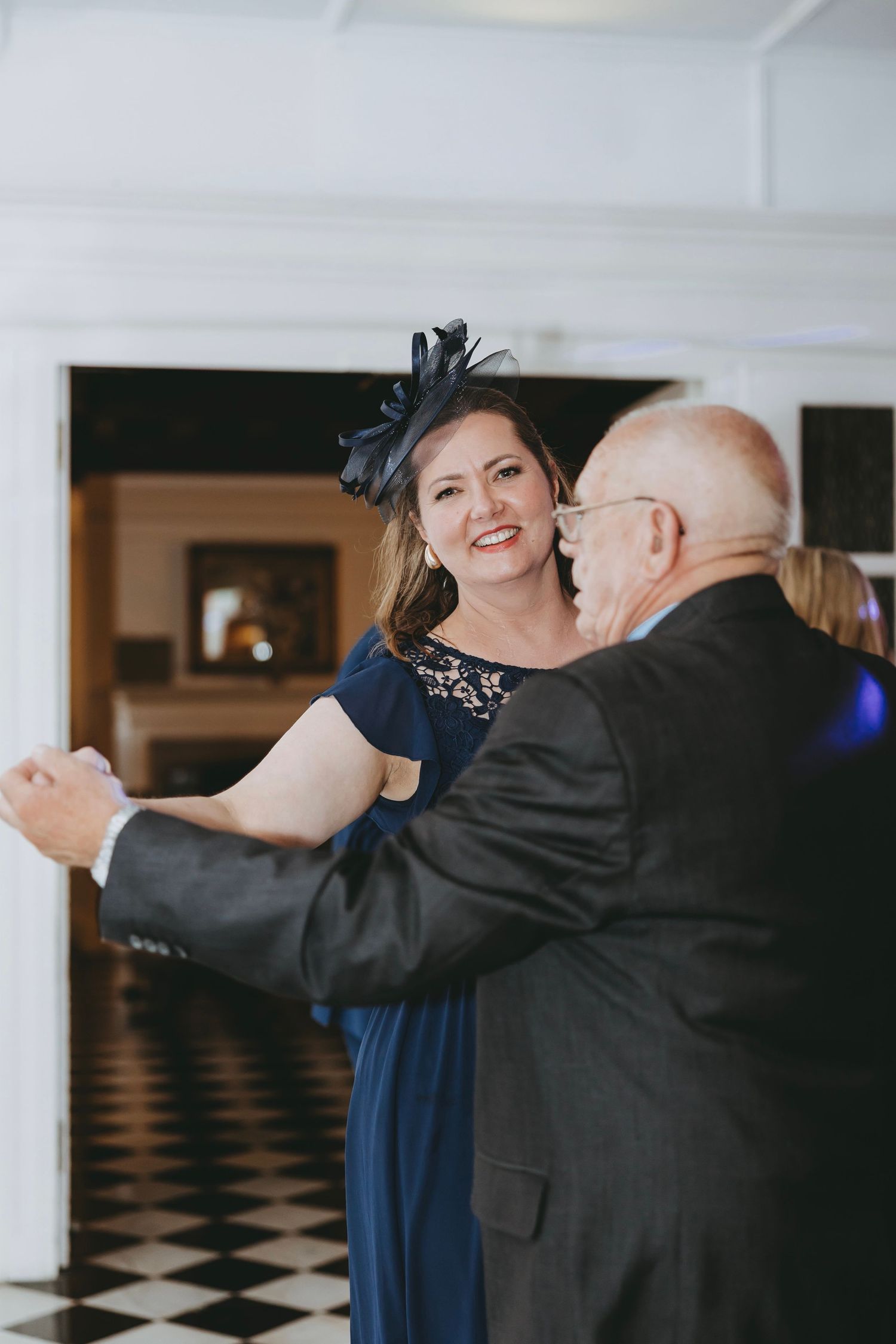 Wedding guests dancing together in formal attire during reception celebration.