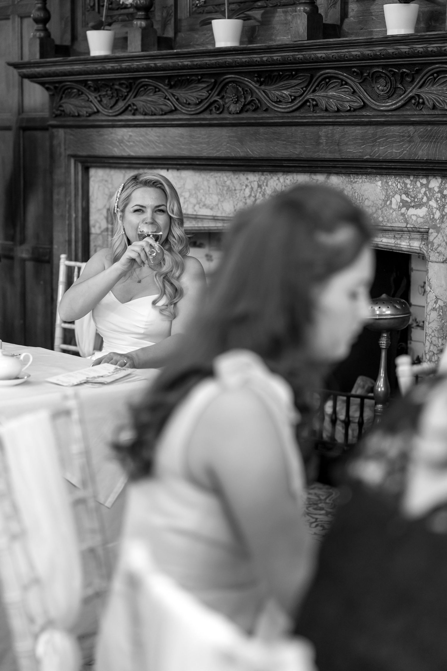 Candid moments captured during an indoor wedding reception with guests seated at decorated tables.