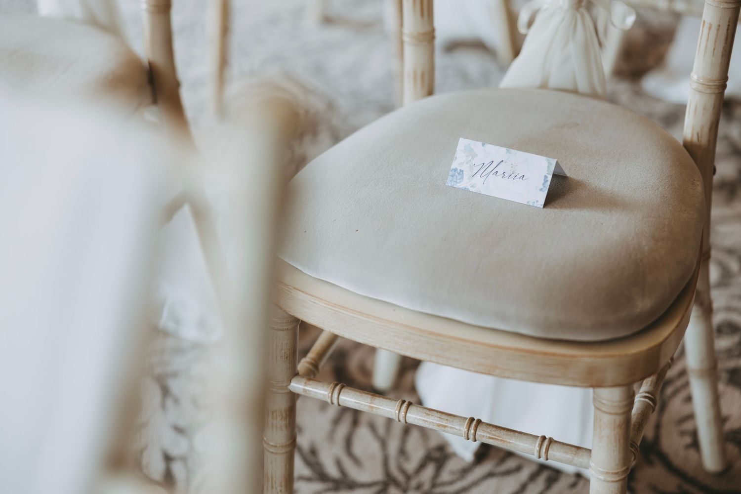 Antique white painted wooden chair with curved back in natural lighting.