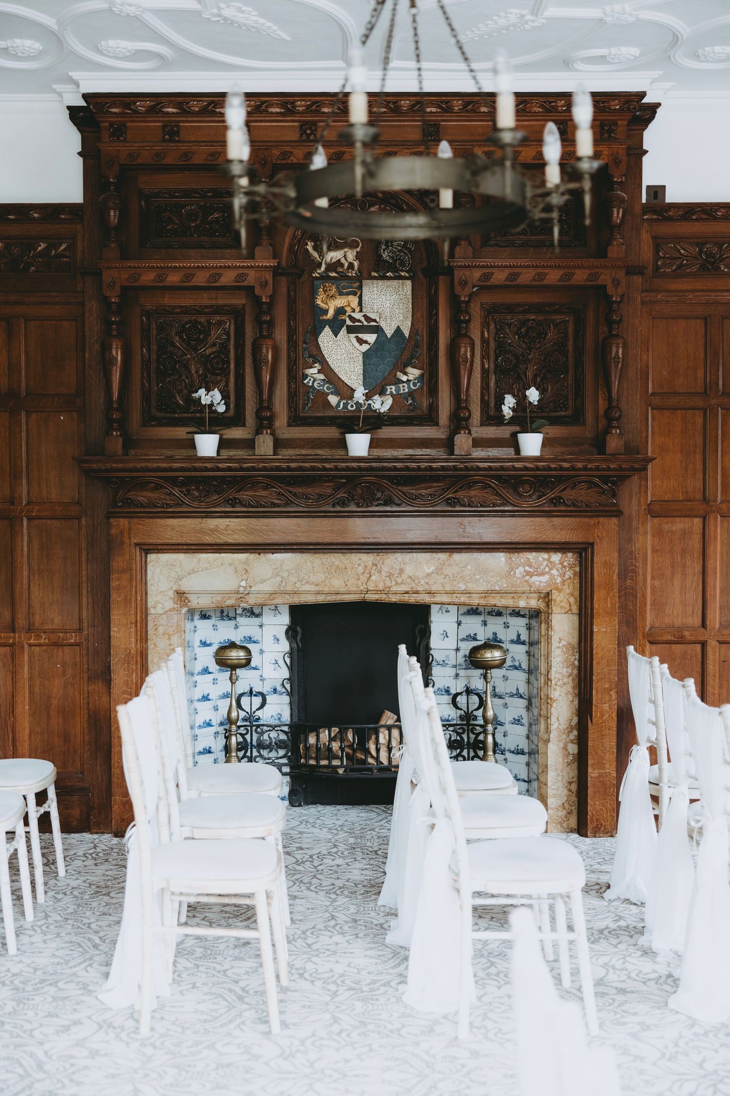 Vintage wood-paneled room with white chairs arranged for a wedding ceremony.
