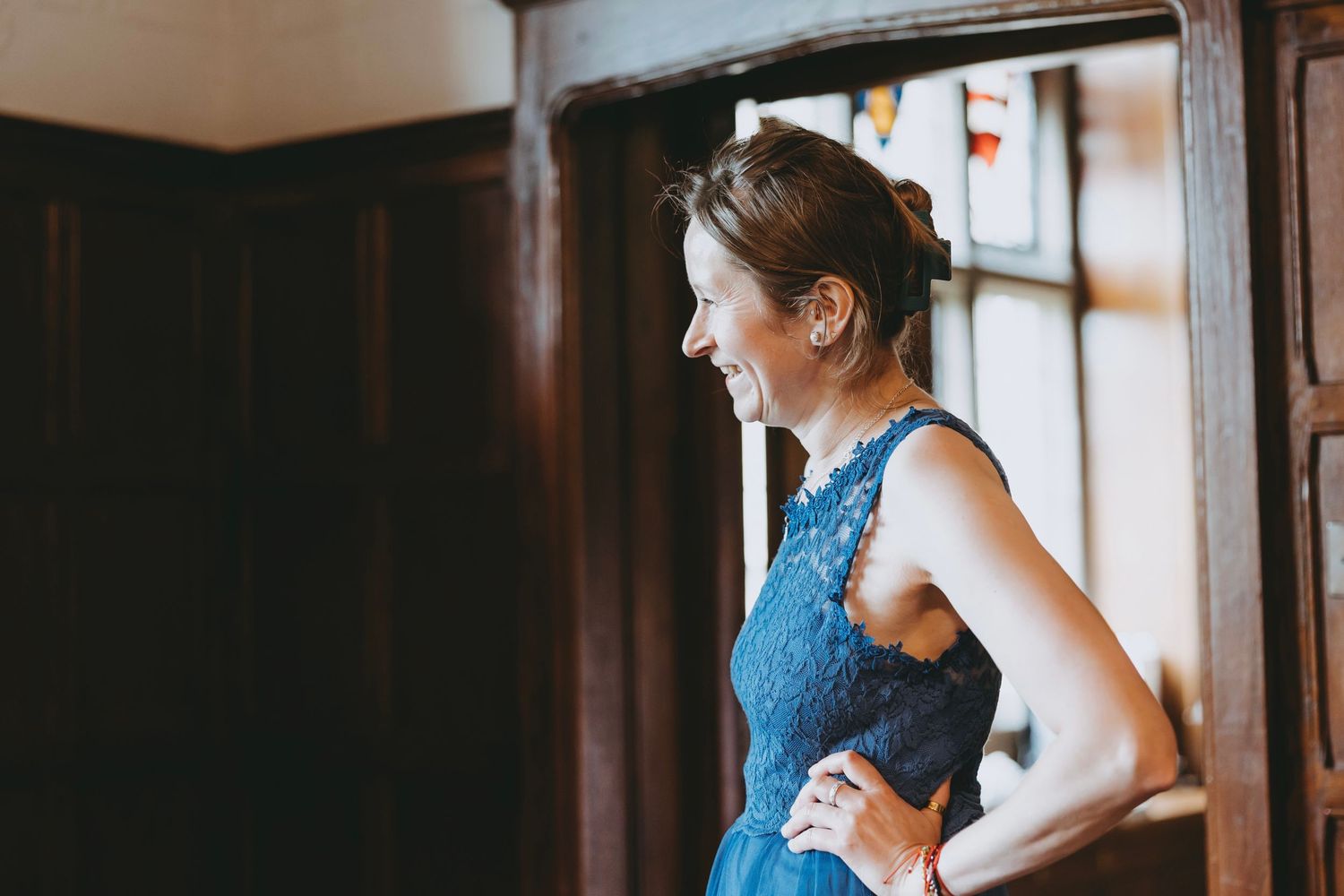 Wedding preparations in an elegant room with dark wood paneling and natural lighting.
