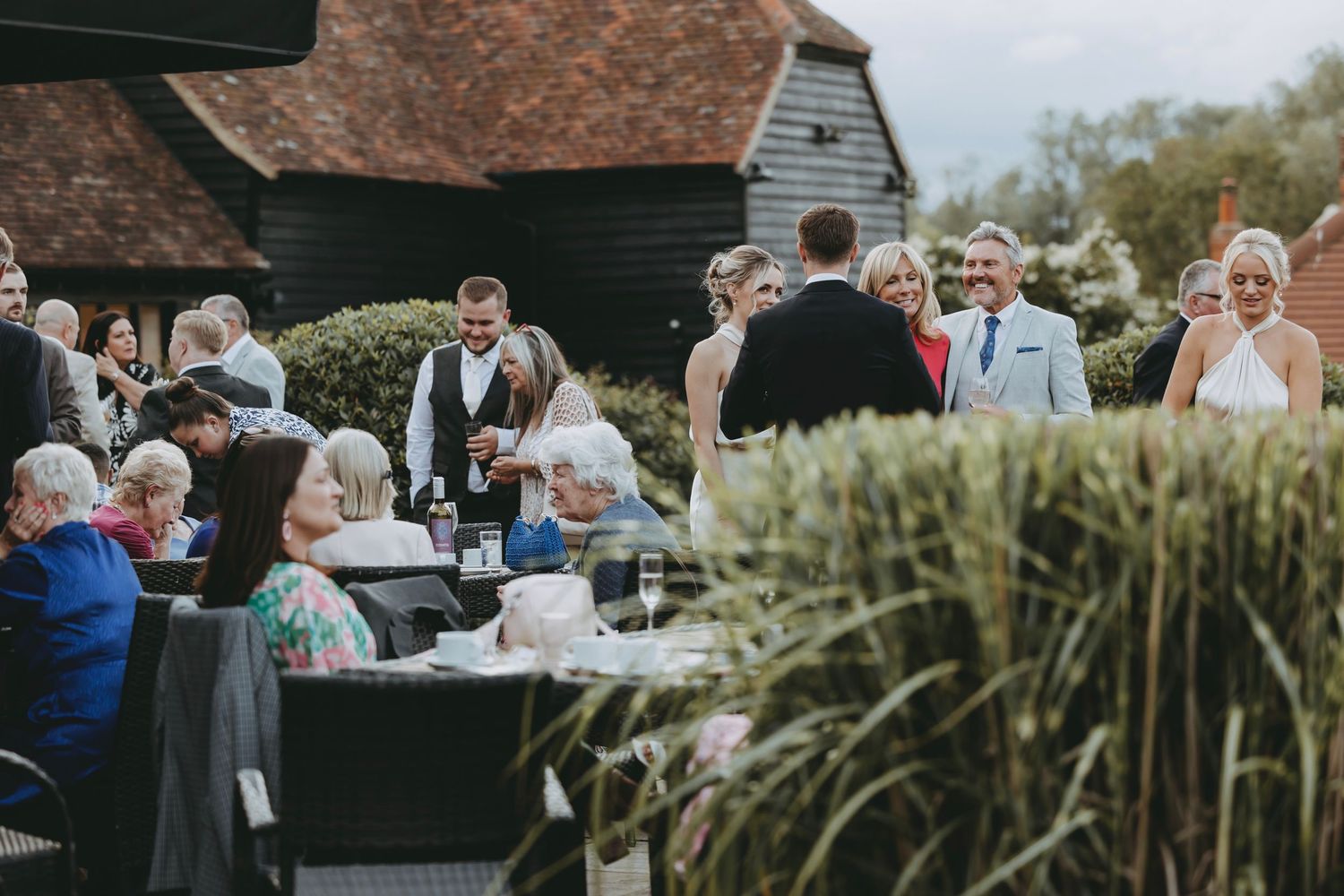 Outdoor wedding reception tables set up with rustic barn backdrop and natural lighting.