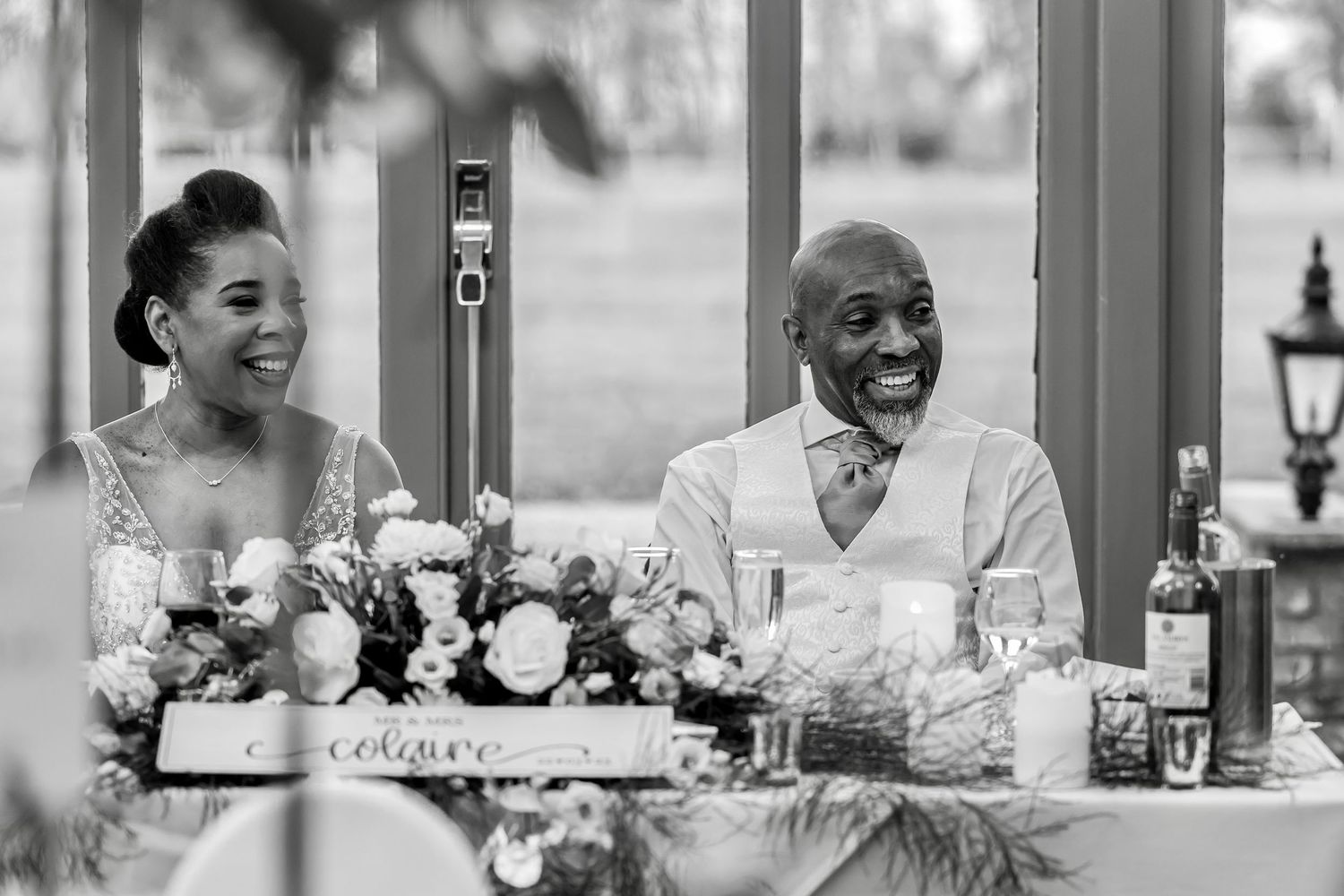 Wedding reception table decorated with floral centerpieces and place settings.