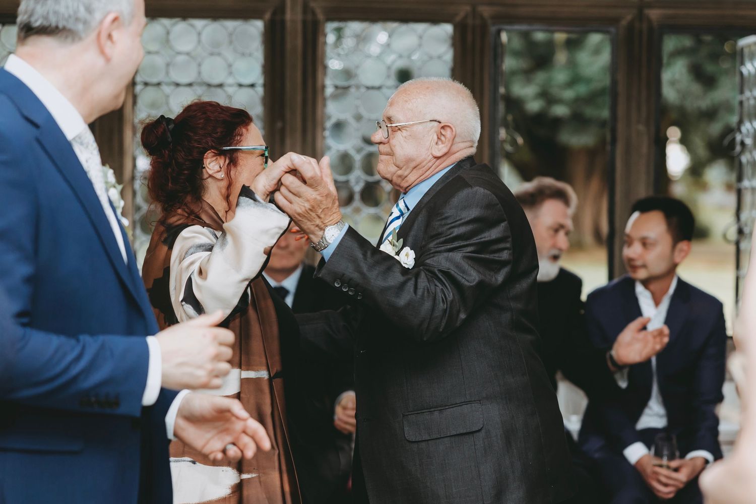 Wedding guests share warm embraces and greetings during the reception celebration.