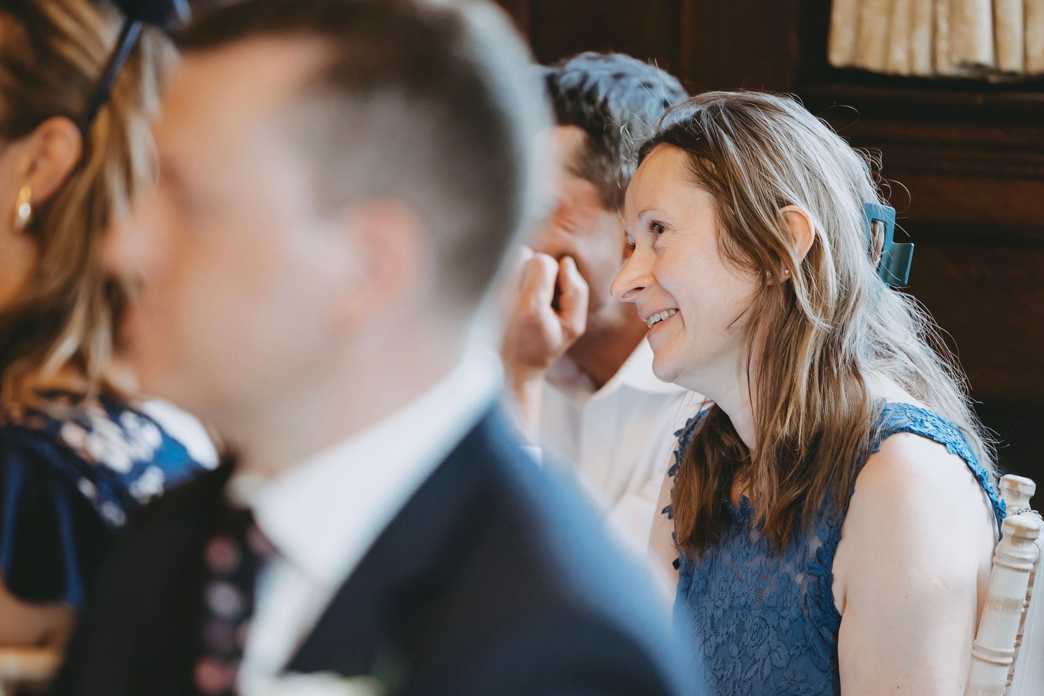 Guests share intimate moments during wedding speeches at an elegant venue.
